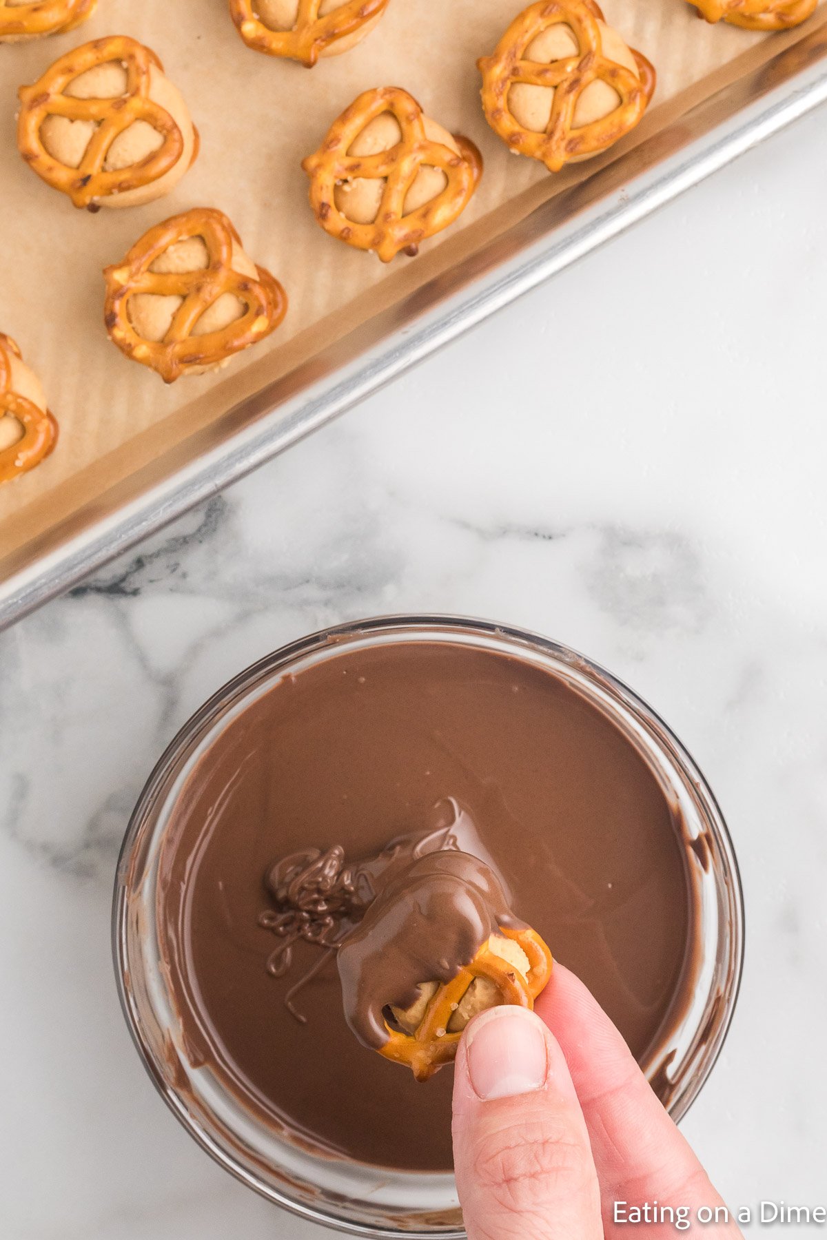 Dipping the pretzel bites into the melted chocolate