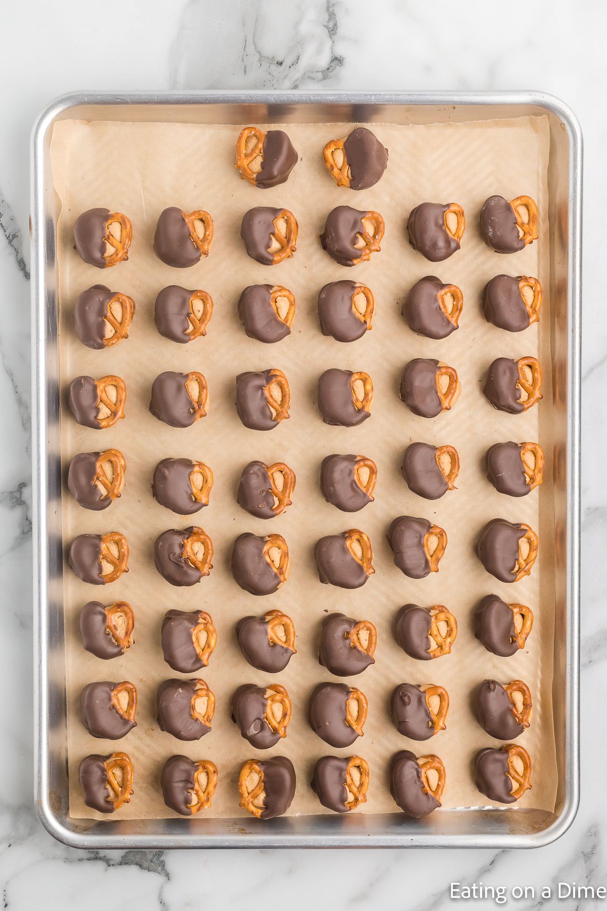 Placing the peanut butter chocolate dipped bites on a baking sheet