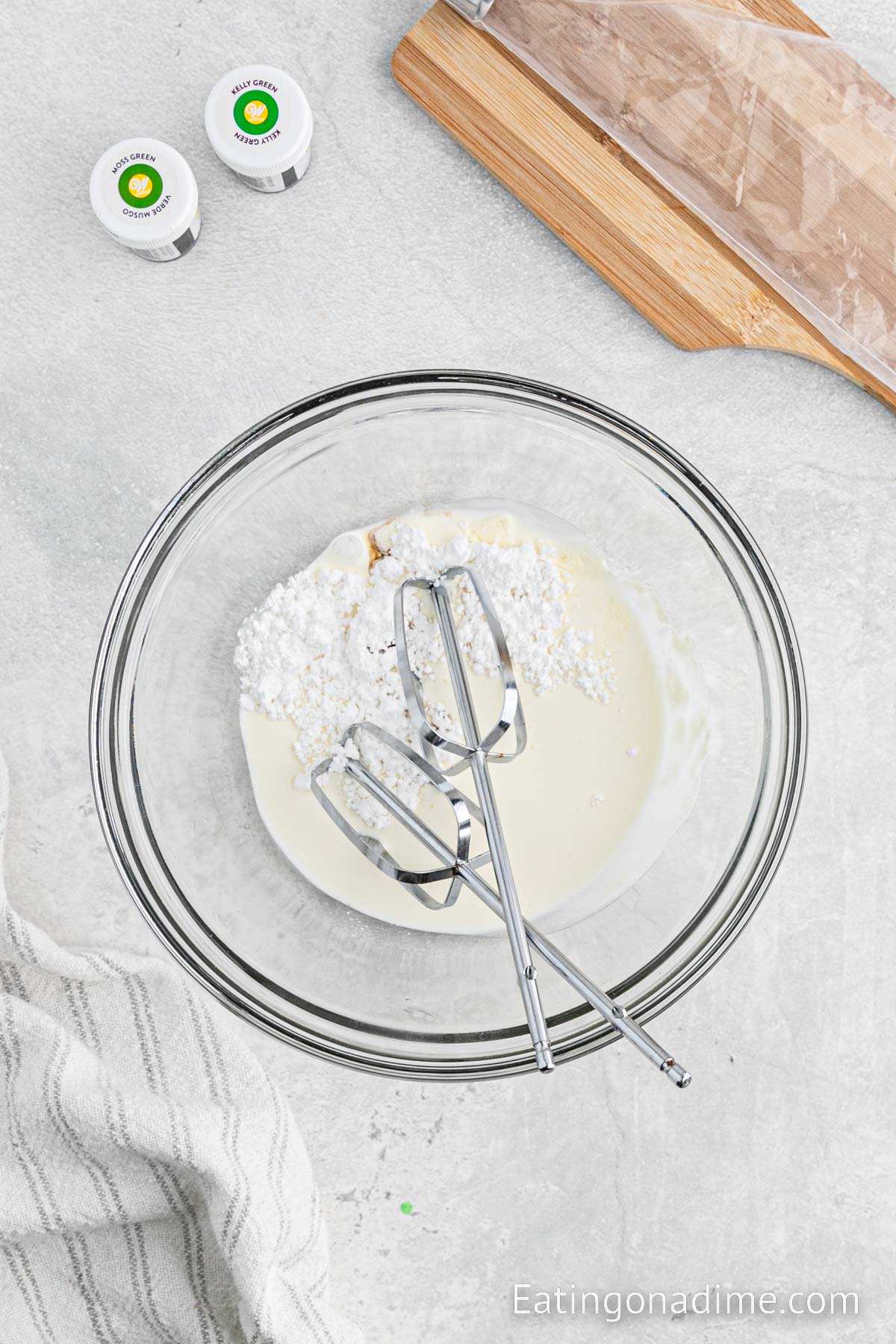 Combining the whipped cream, powdered sugar and vanilla in a bowl with a hand held mixer