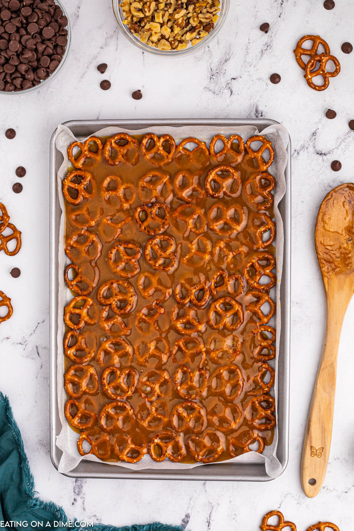 The mixture is poured over the pretzels on a baking sheet
