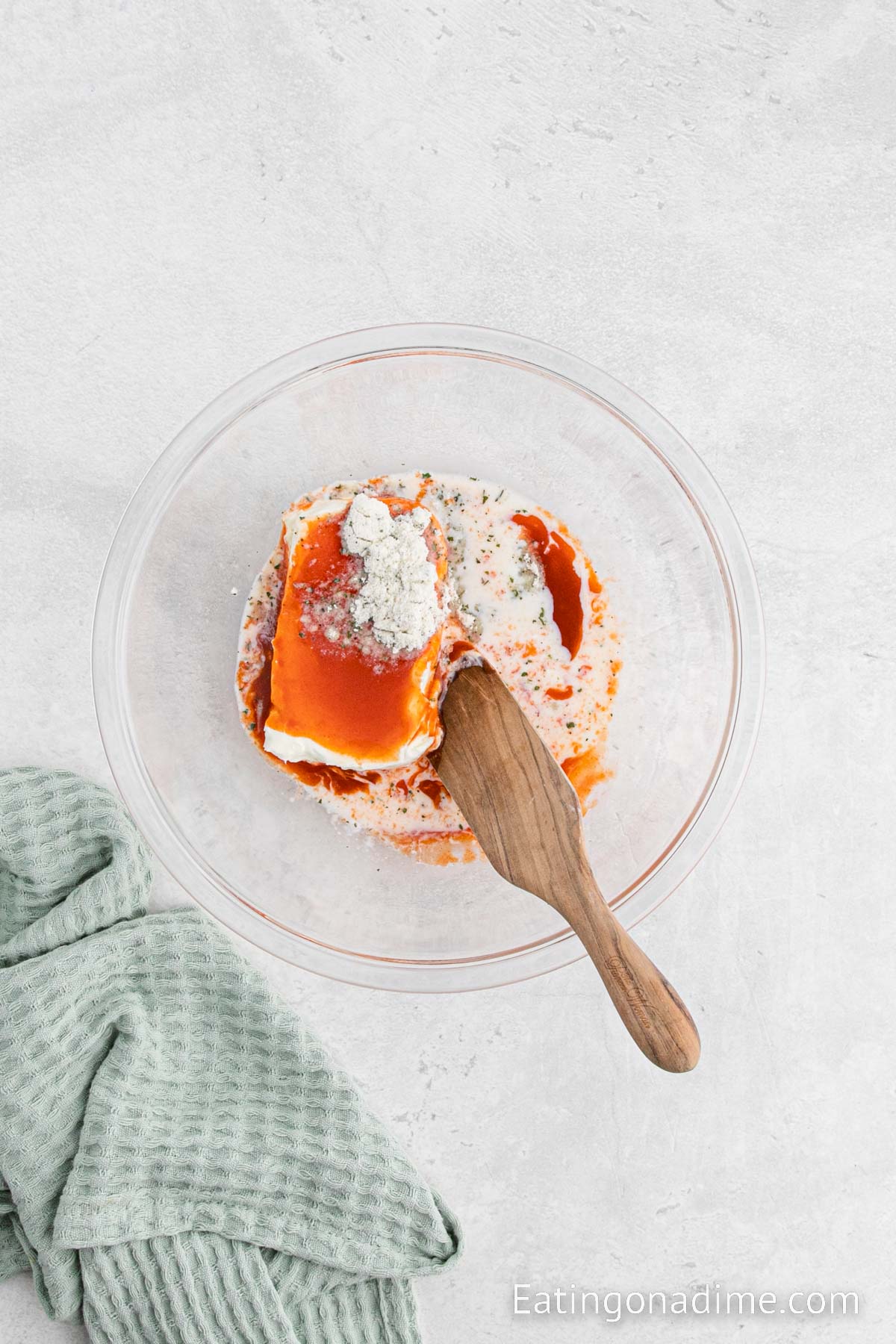 Combining the cream cheese, buffalo sauce and seasoning in a bowl