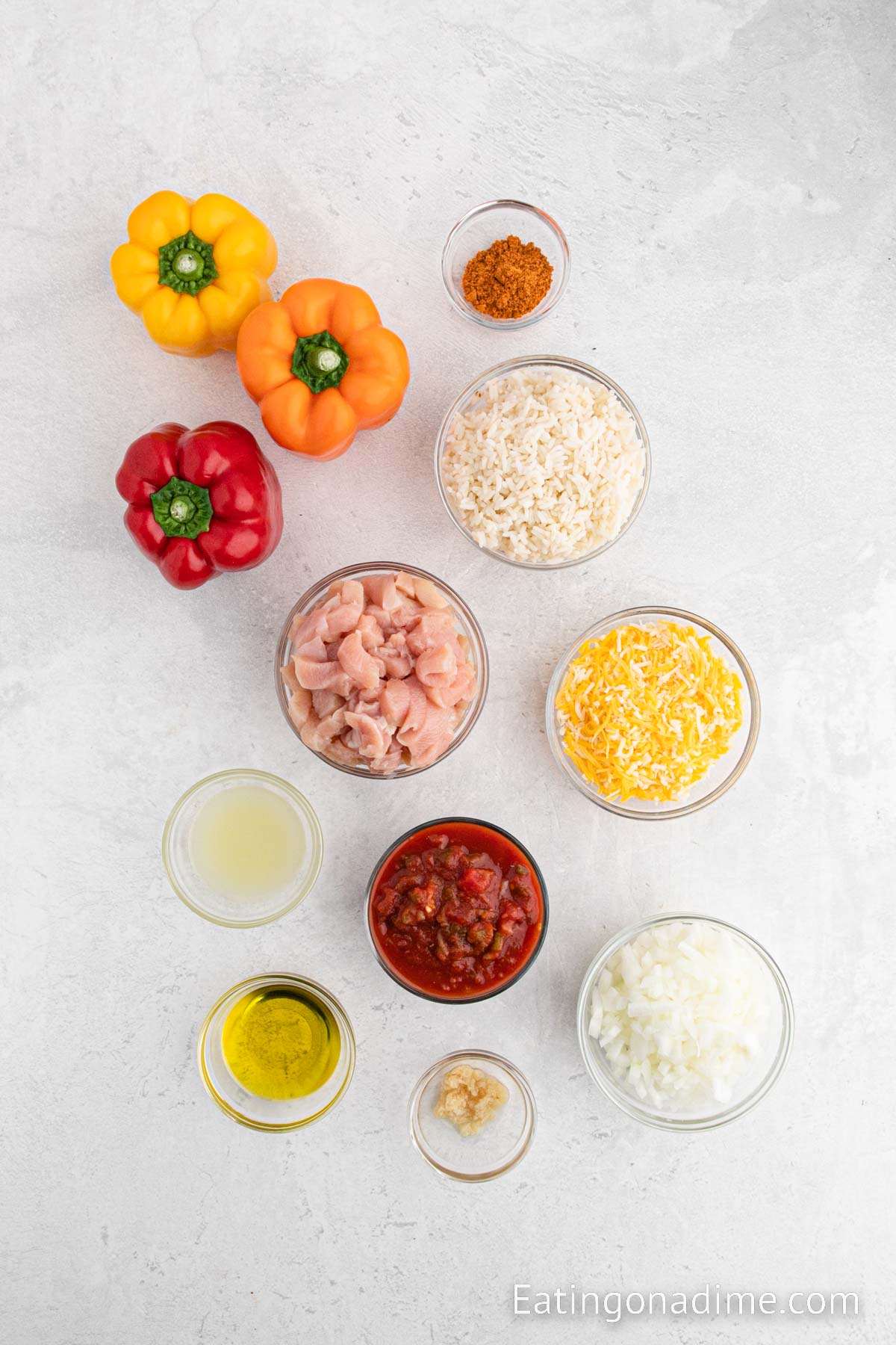 Chicken Stuffed Peppers ingredients - bell peppers, olive oil, onion, minced garlic, chicken breasts, taco seasoning, salsa, white rice, lime, cheese
