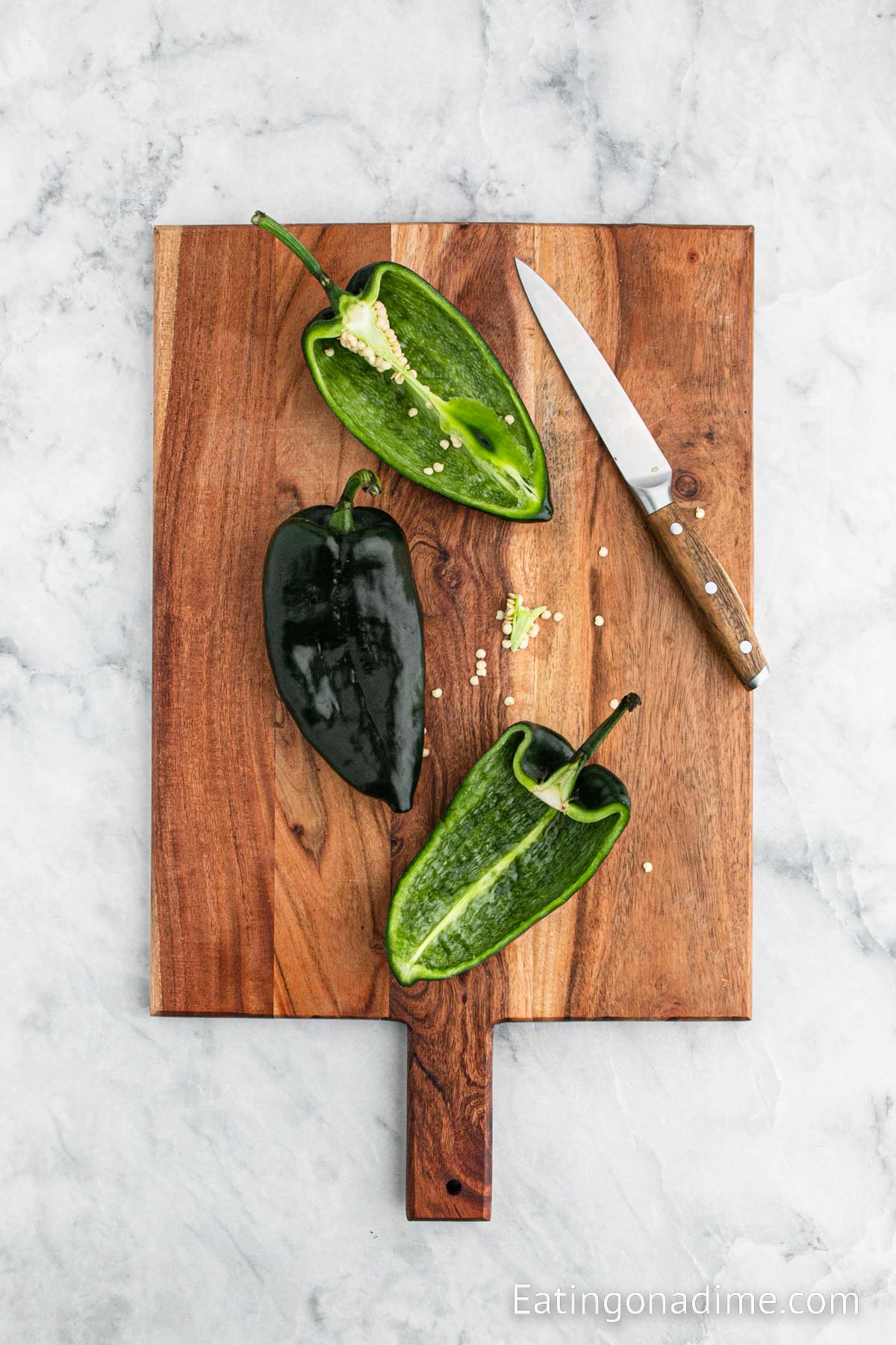 Preparing the poblano peppers by cutting and removing seeds on a cutting board