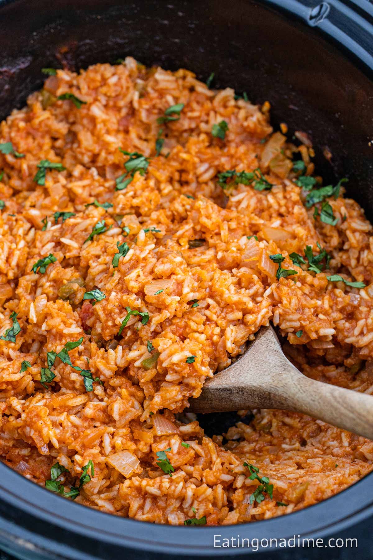 Spanish Rice in the slow cooker with the wooden spoon