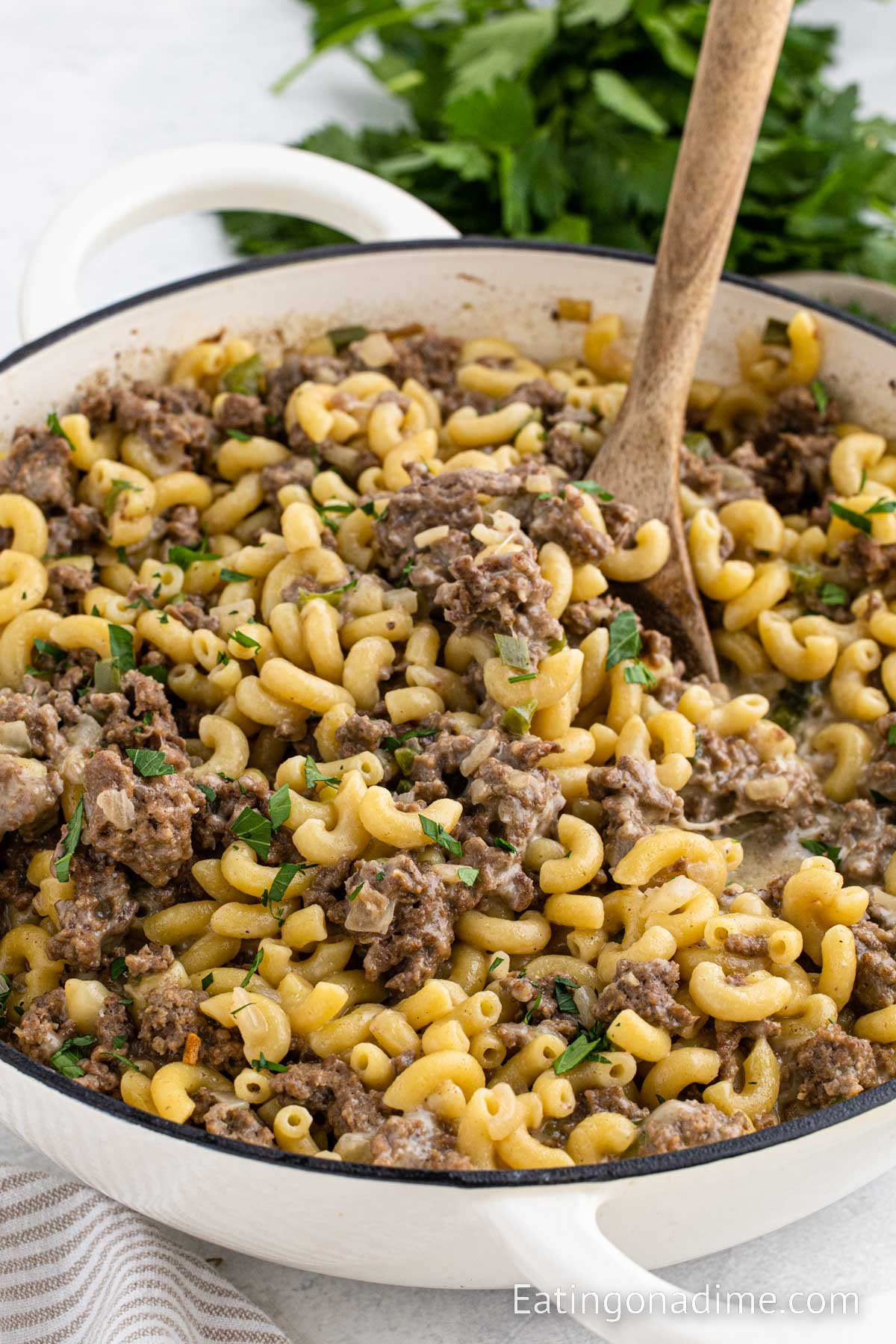 Skillet Philly Cheesesteak Pasta with a serving on the wooden spoon