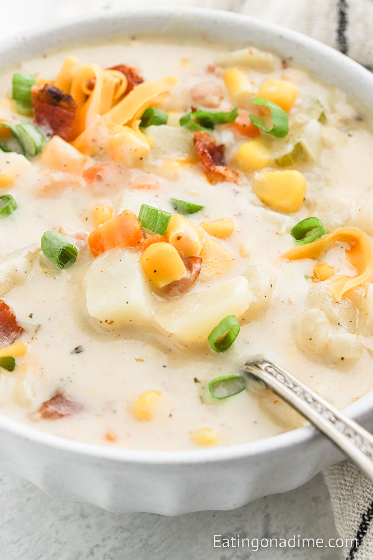 Potato Corn Chowder in a bowl topped with cheese and green onions