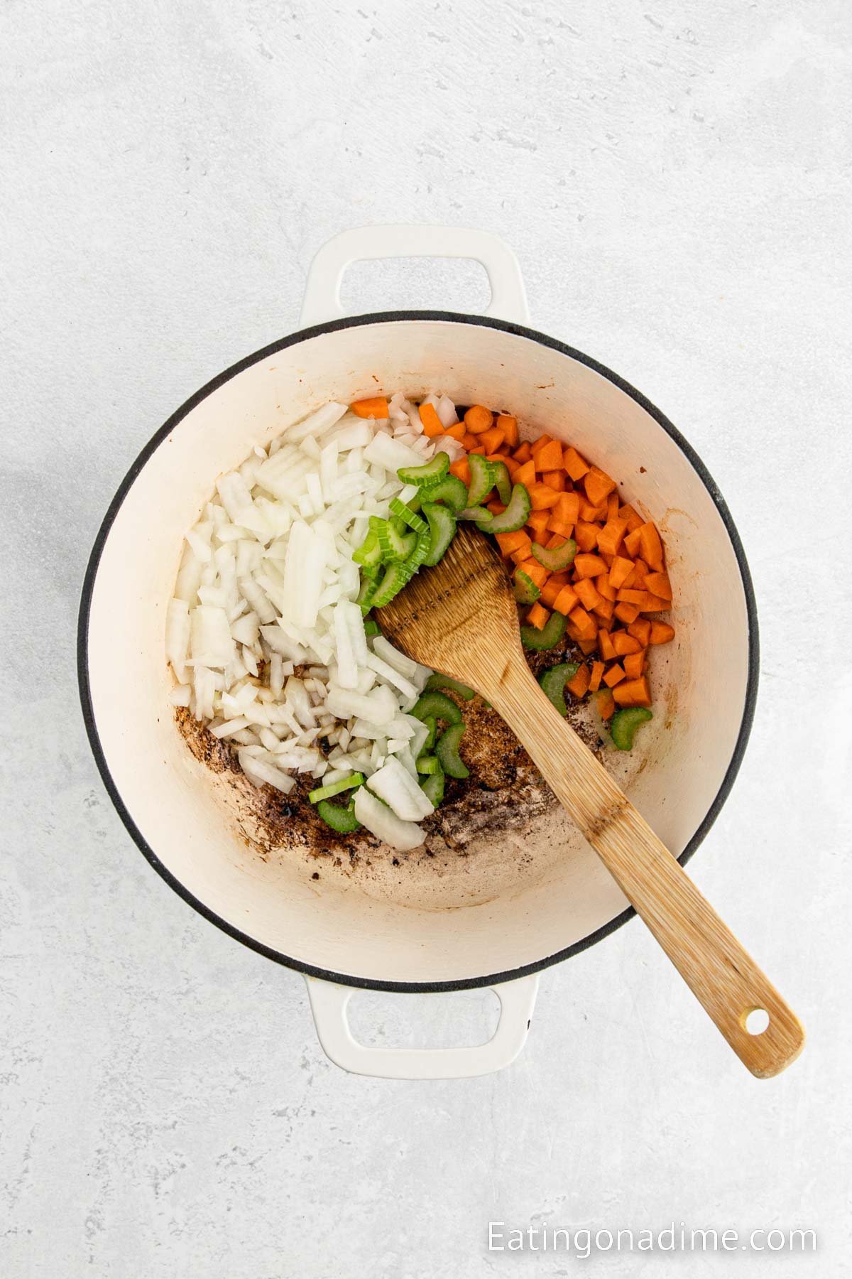 Cooking vegetables in a large pot with a wooden spoon