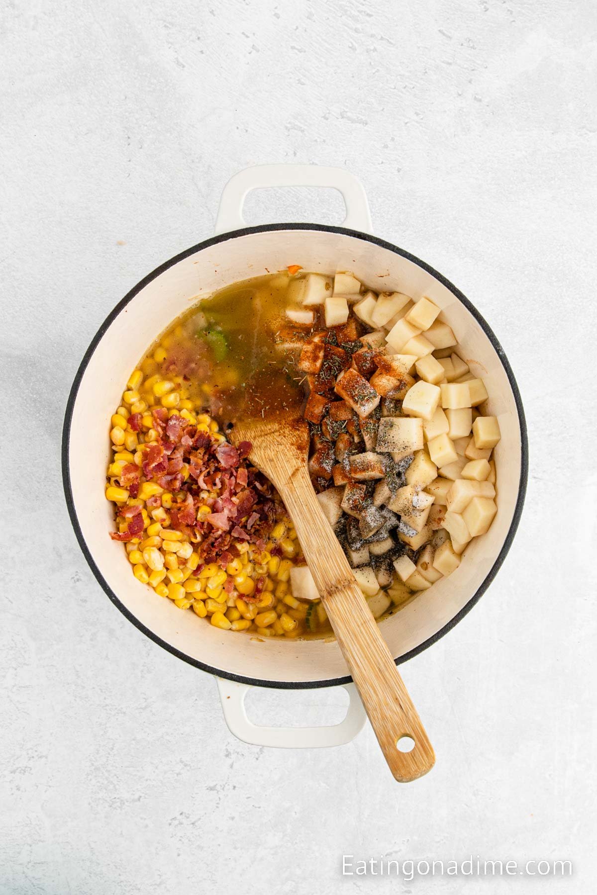 Adding the remaining ingredients in the large pot with a wooden spoon