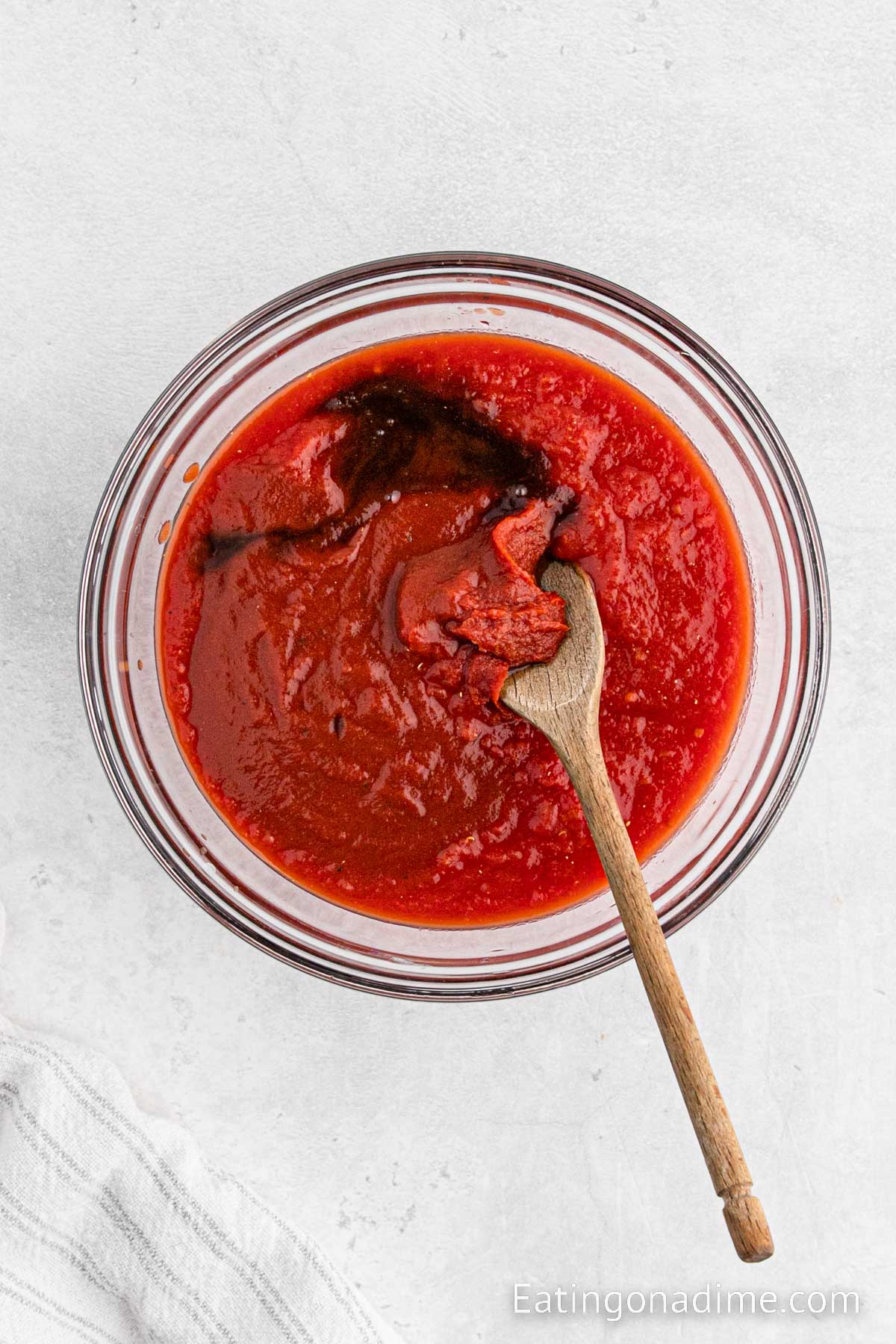 Mixing the sauce in a bowl with a wooden spoon