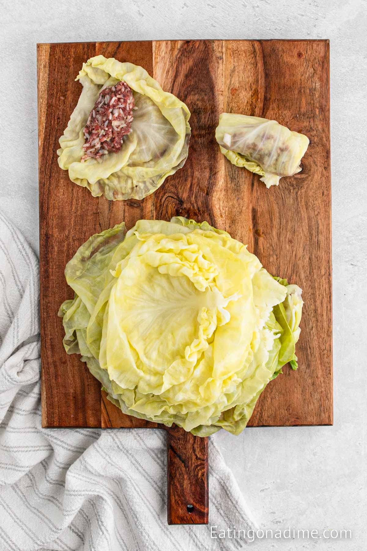 Preparing the cabbage rolls by rolling in the meat mixture