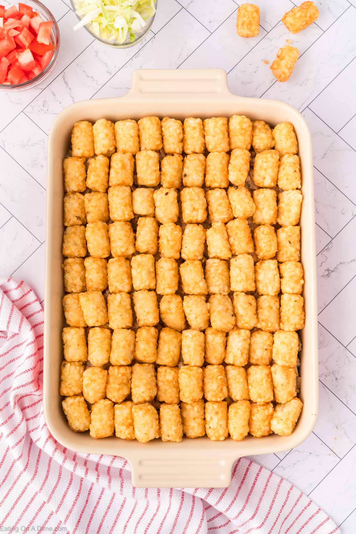 Tator Tots lined in a baking dish topped over the ground beef mixture