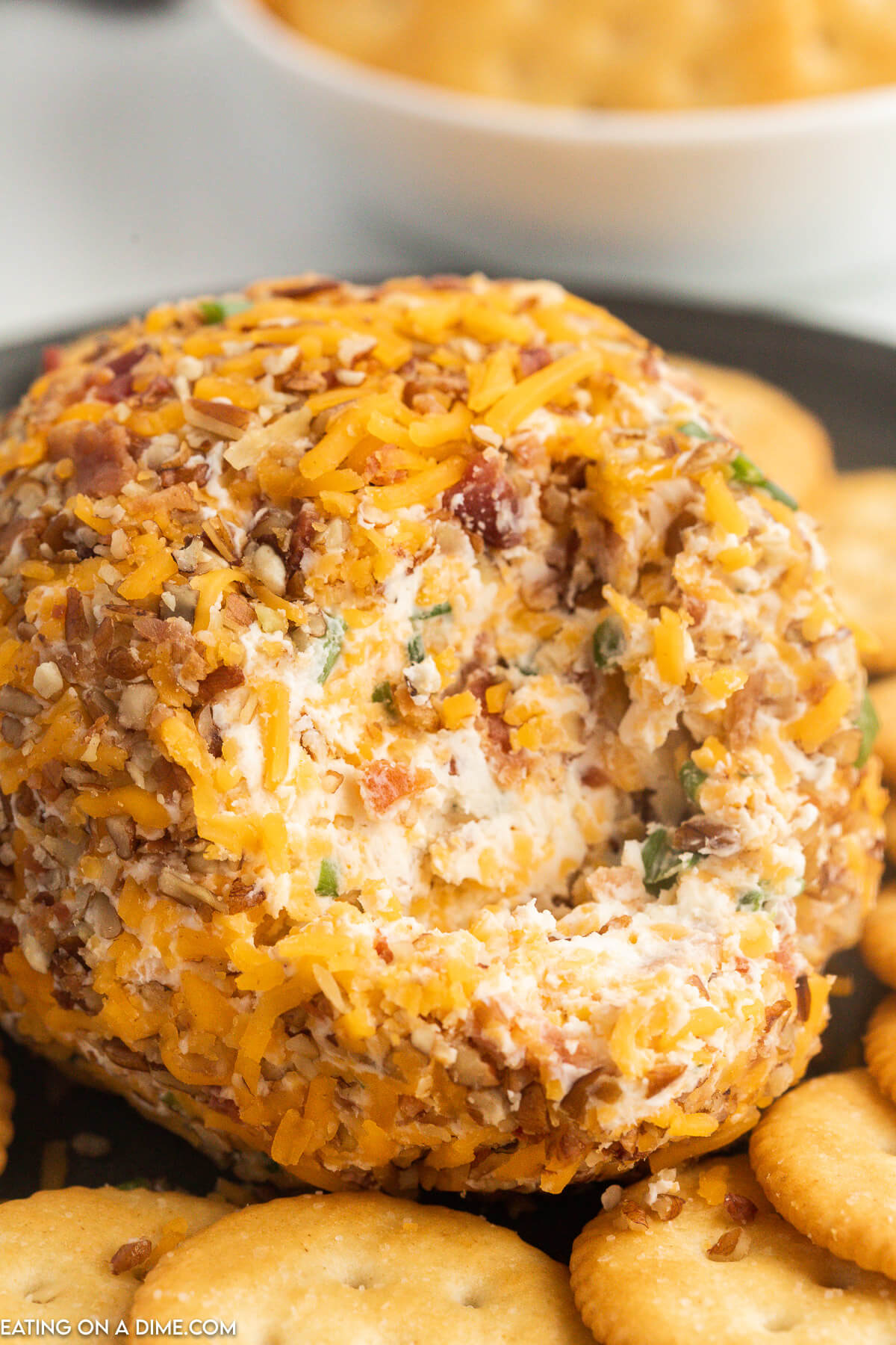Close up image of Bacon Ranch Cheese Ball on a platter with crackers
