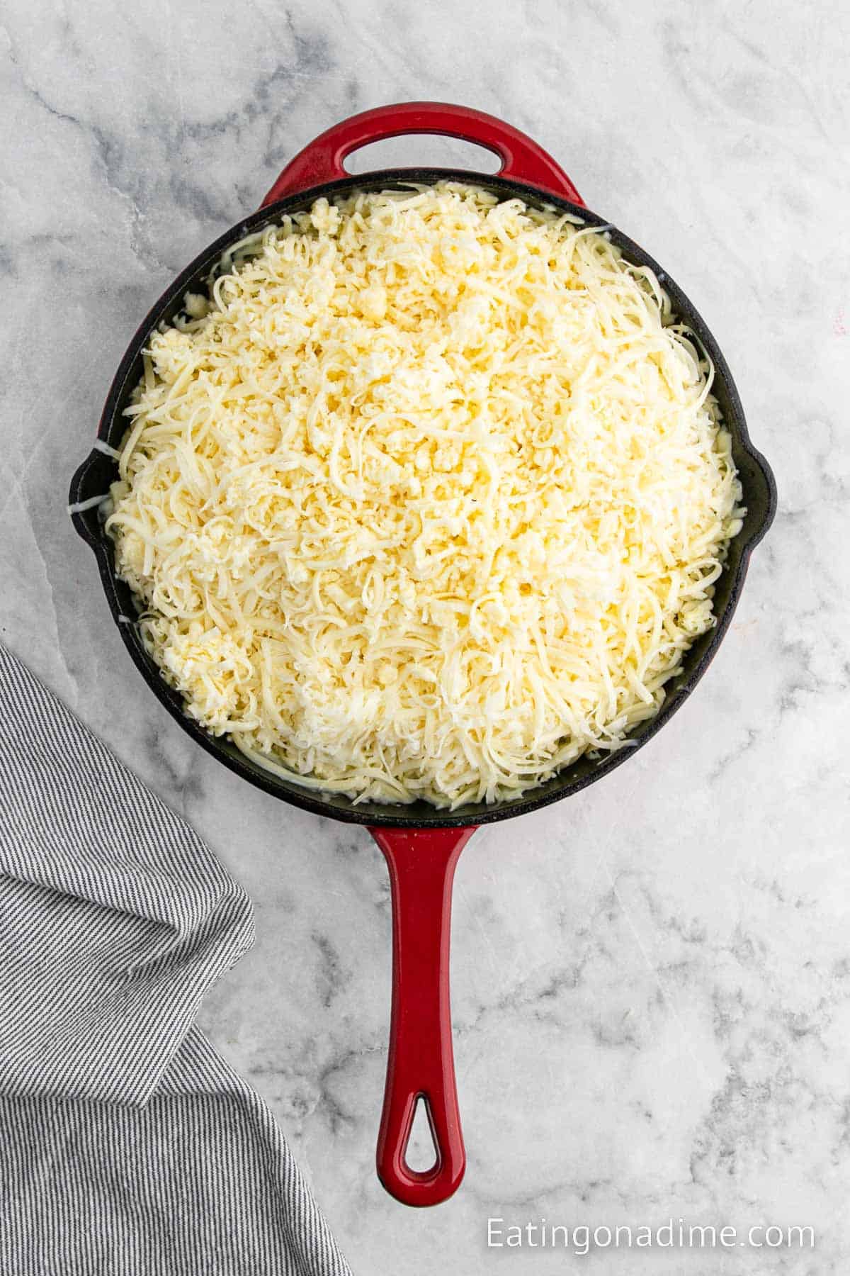 Adding shredded cheese to the cooked chorizo