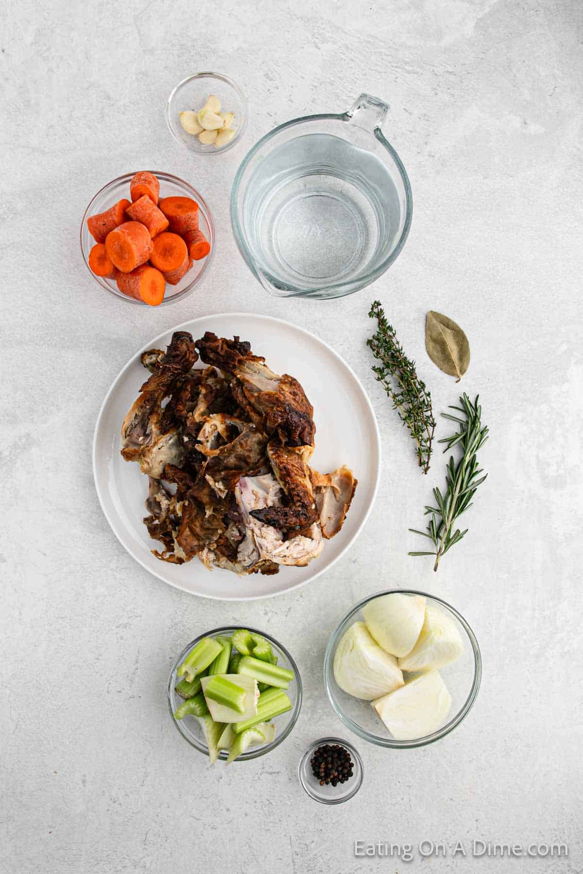 Chicken Stock Ingredients - chicken carcass, carrots, celery, onion, garlic, bay leaf, black peppercorns, thyme, rosemary, water