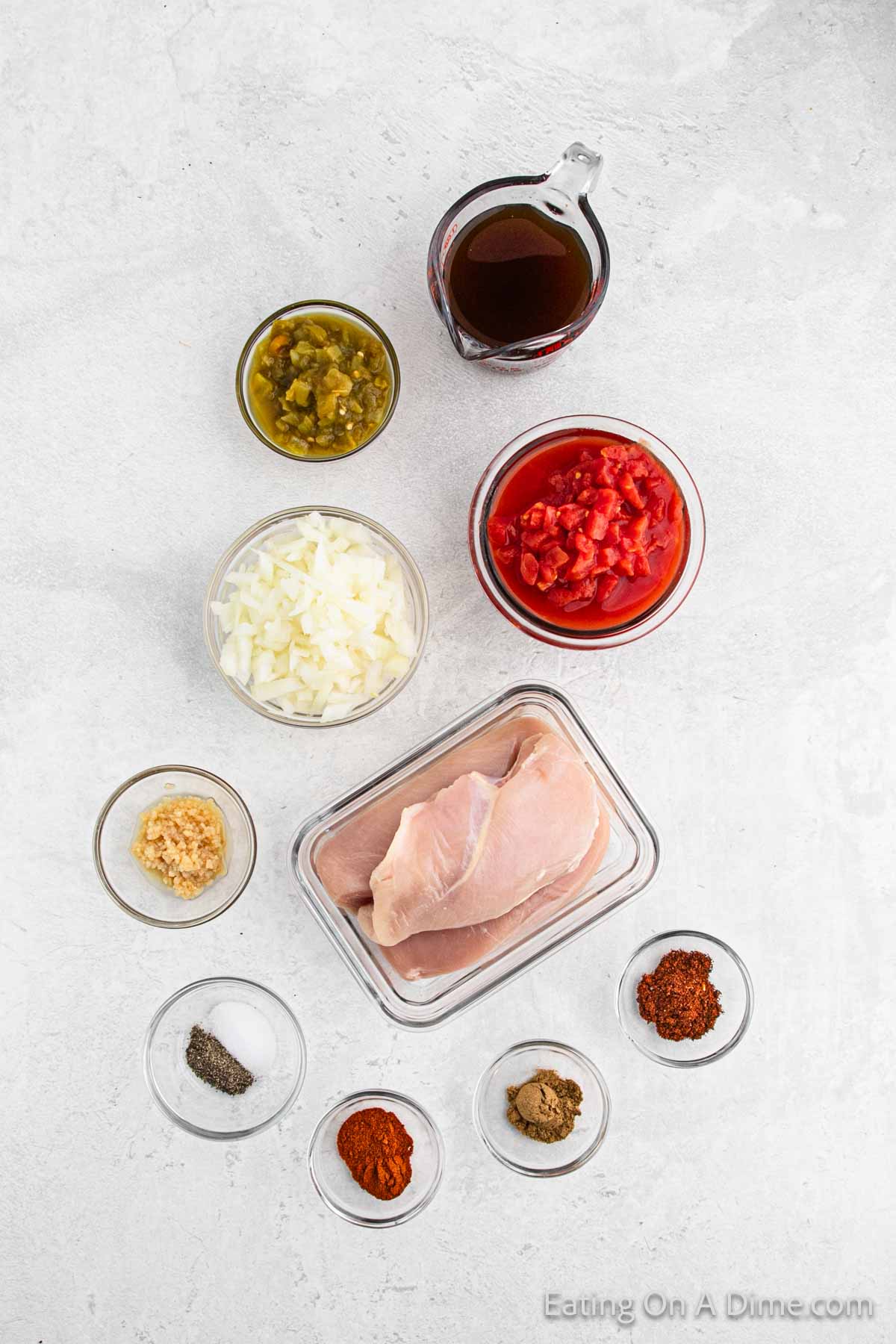 Mexican Chicken ingredients - chicken breasts, diced tomatoes, green chilies, onion, garlic, cumin, paprika, chili powder, salt and pepper, chicken broth