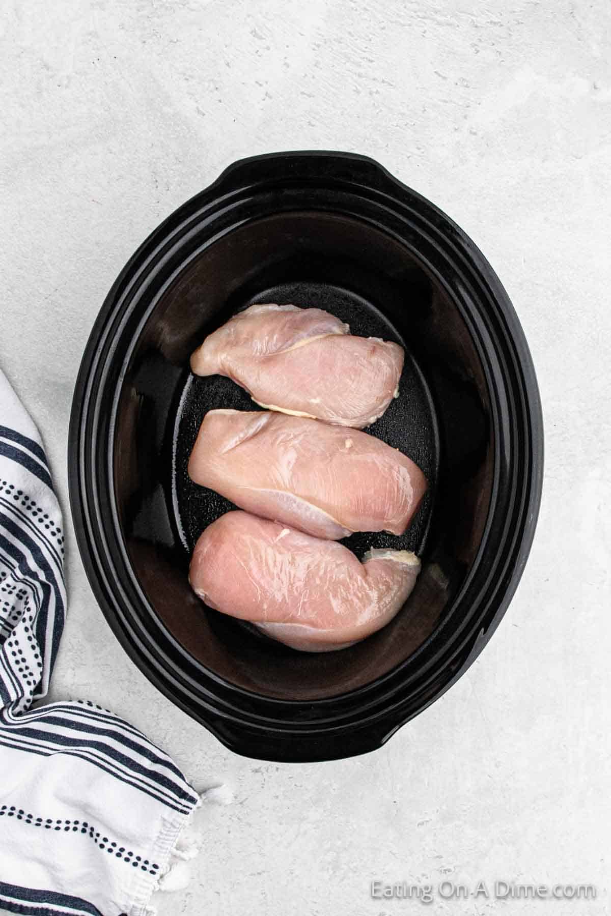 Placing the chicken breast in the slow cooker