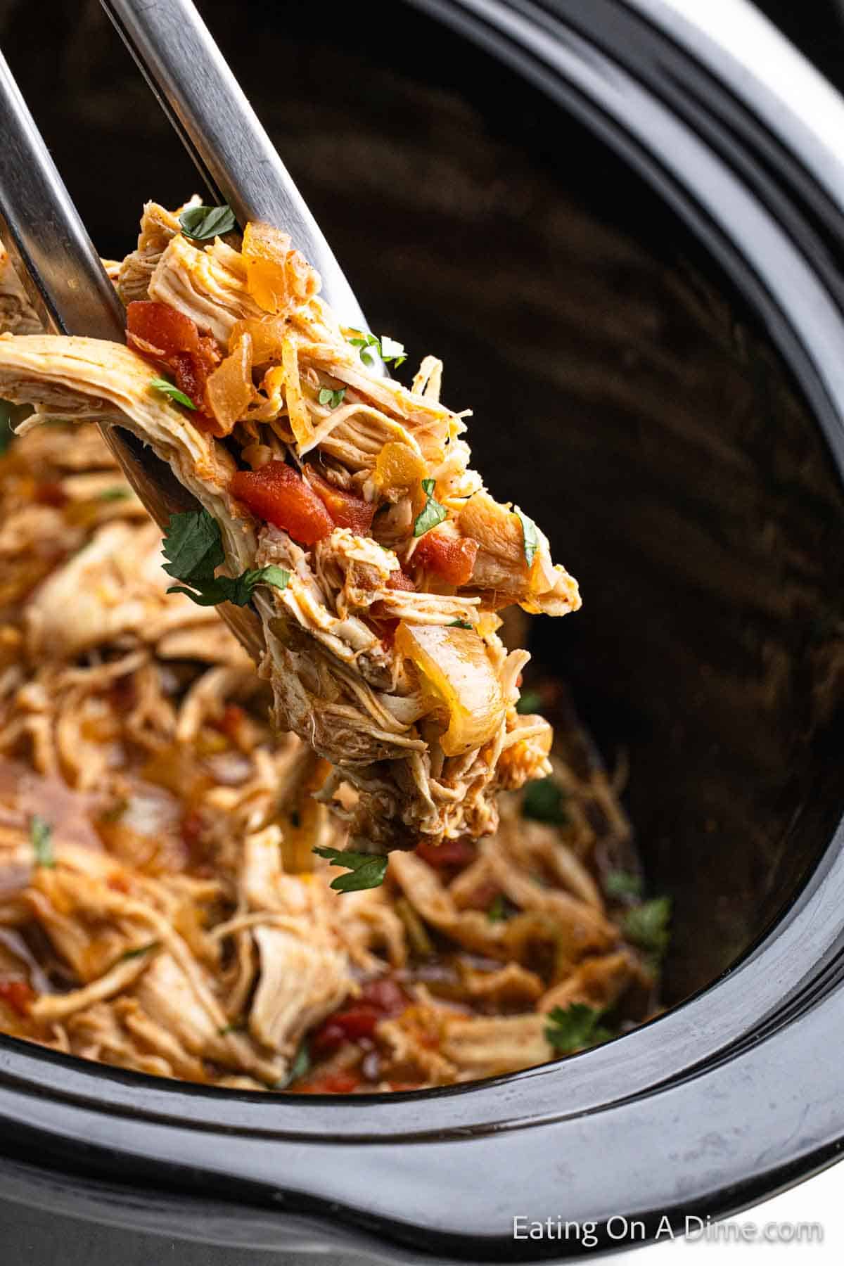 Mexican Chicken in the slow cooker with a serving on tongs