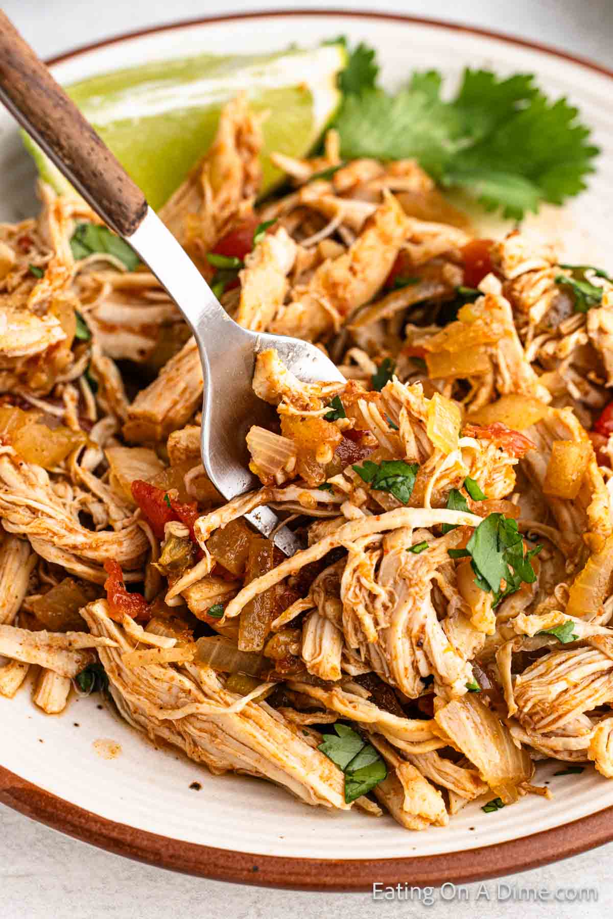 Shredded Mexican Chicken on a plate with a bite on a fork