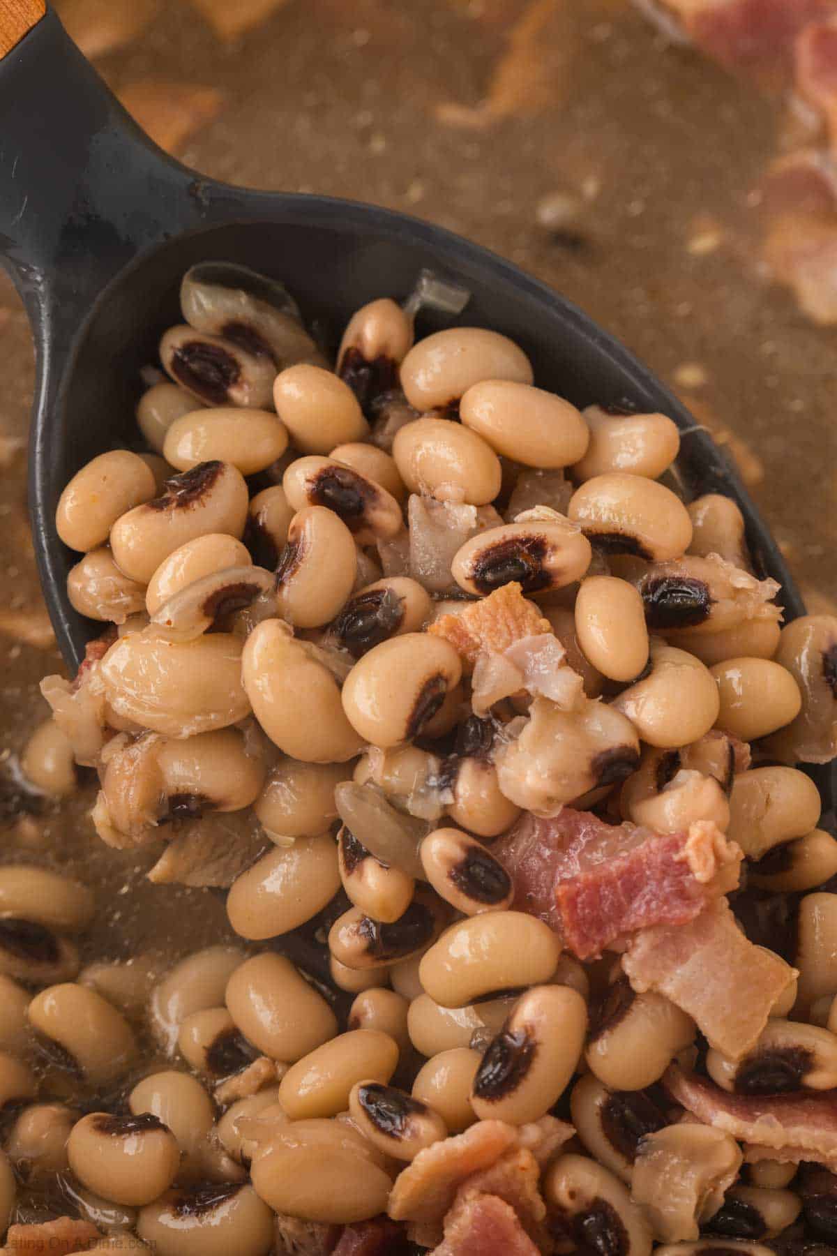 Black Eyed Peas in a large pot with a serving on a spoon