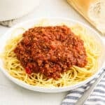 Bolognese Sauce on top of spaghetti noodles on a plate.