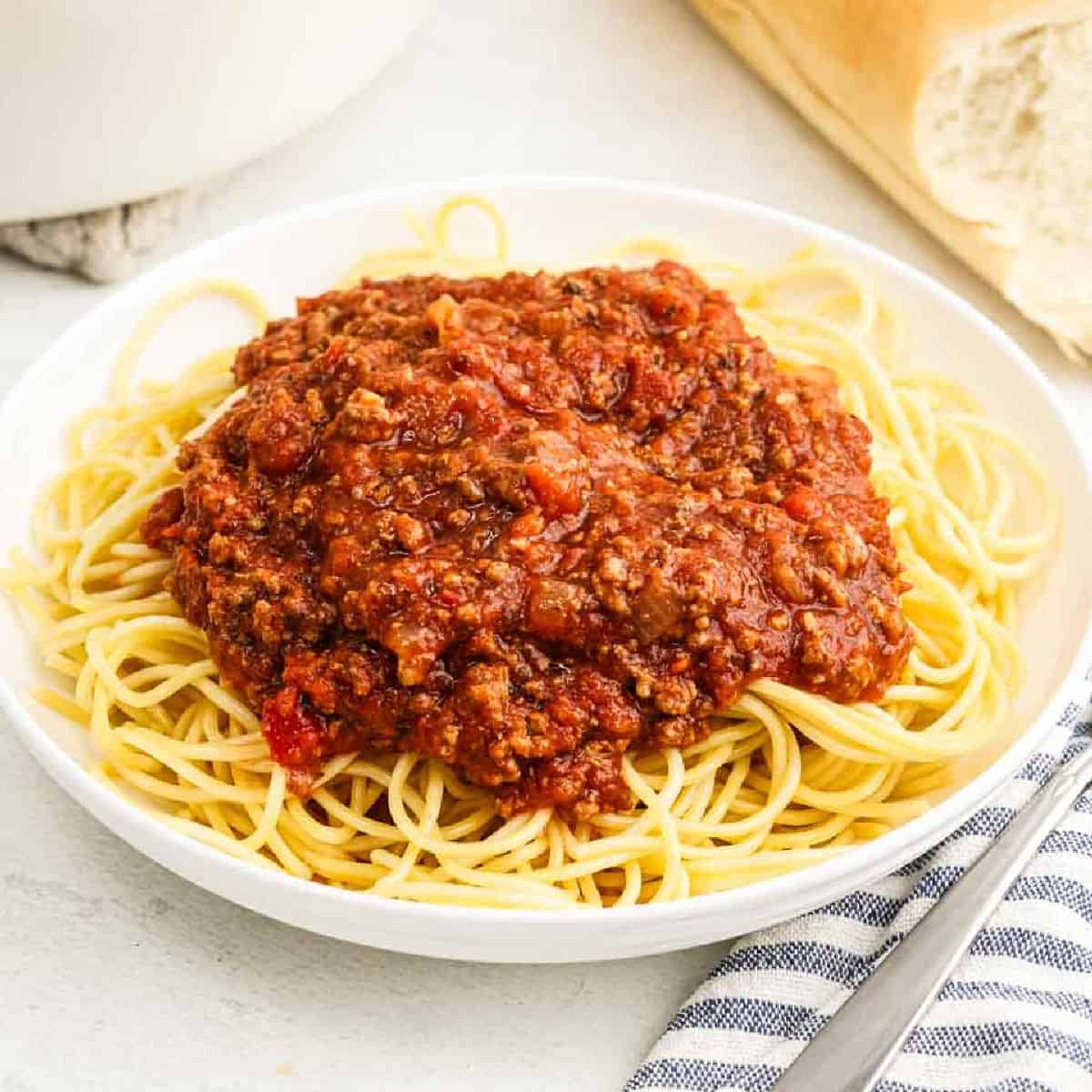 Bolognese Sauce on top of spaghetti noodles on a plate.