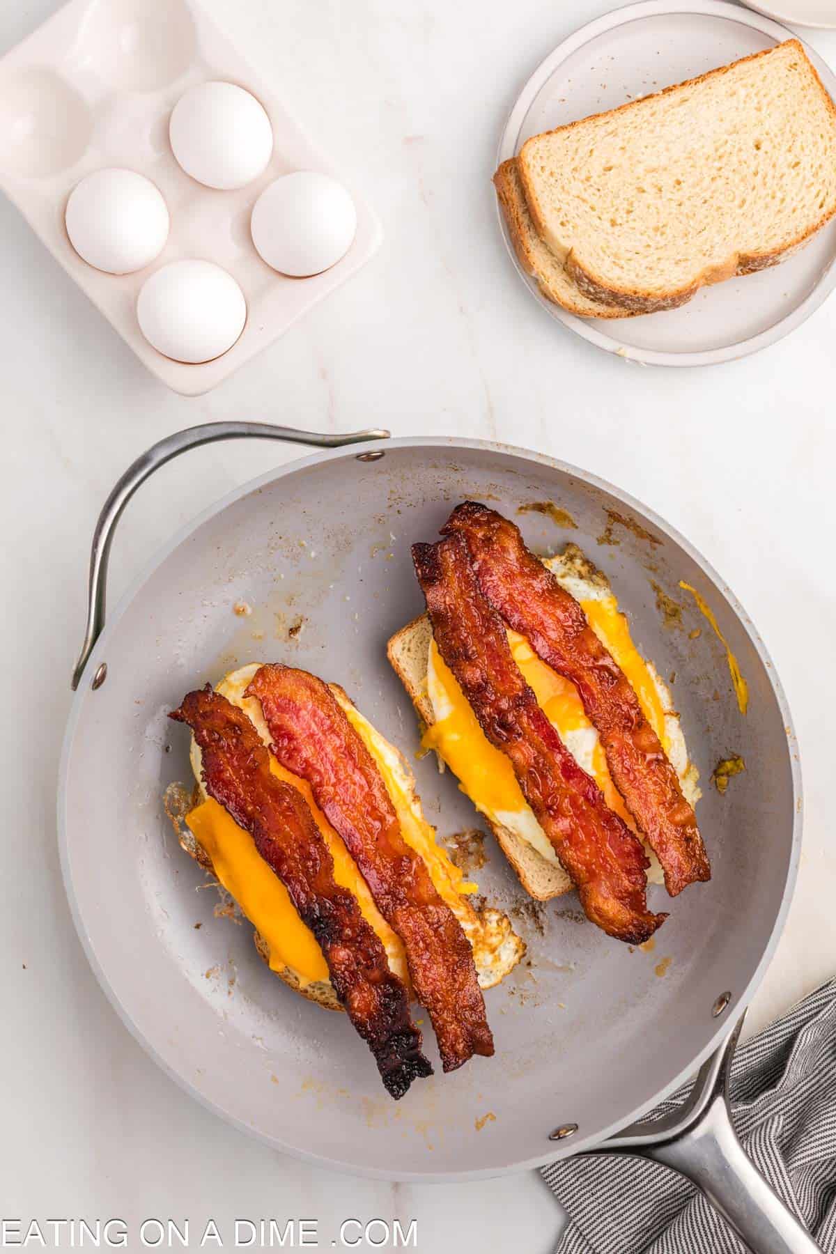 Topping the bread with the fried egg and crispy bacon