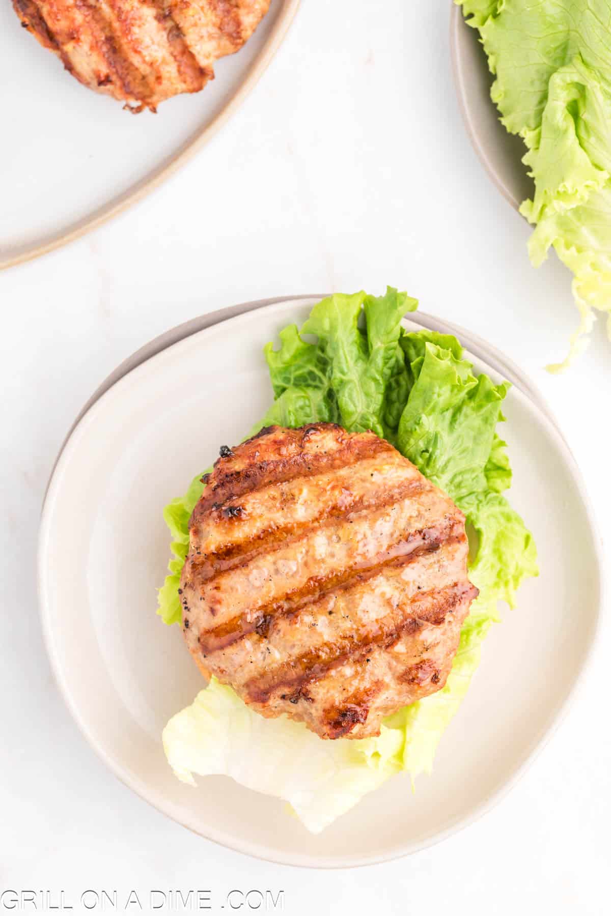 topping the lettuce with ground turkey pattie