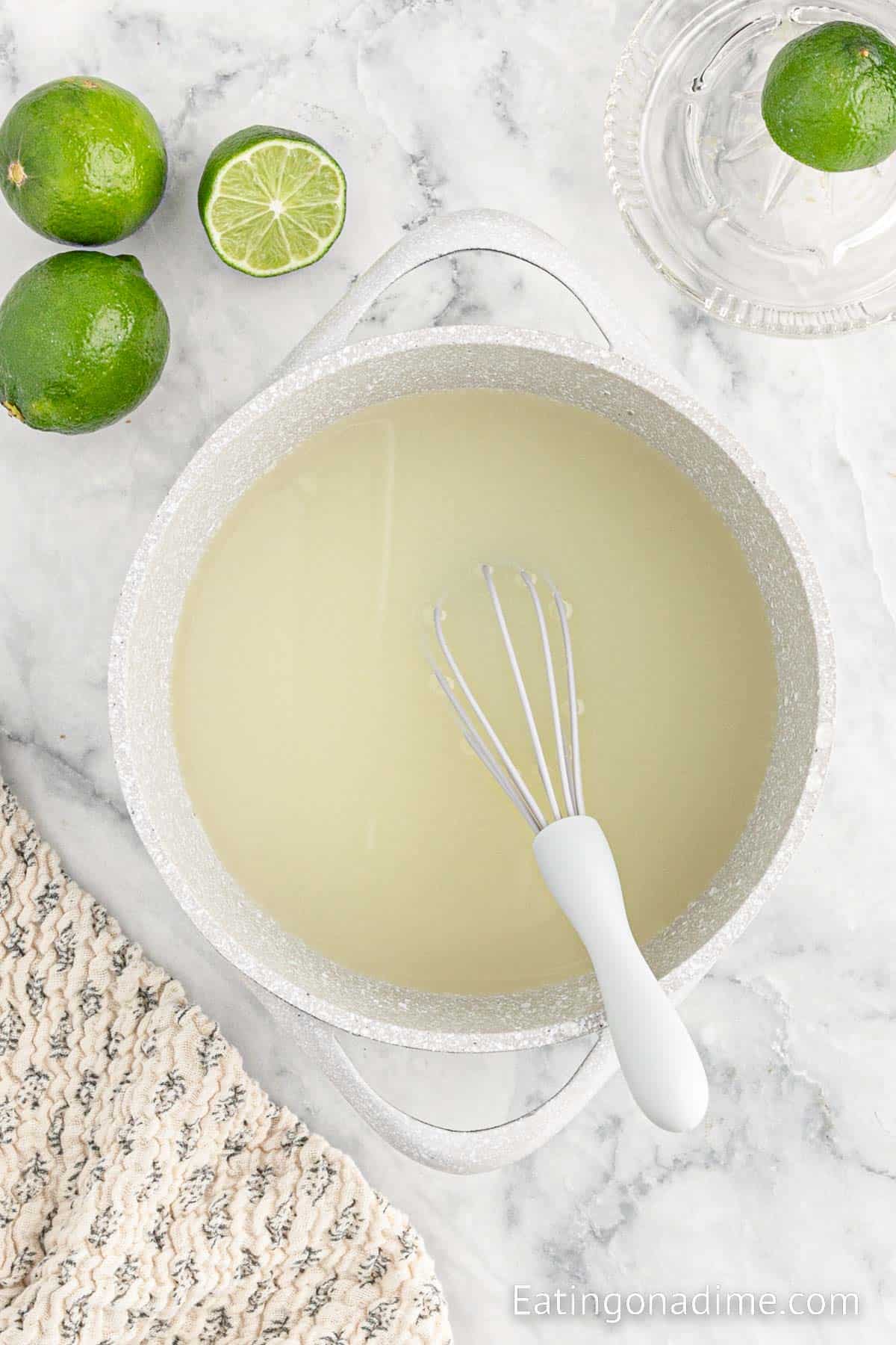 Whisking together water and lime together in a large pot