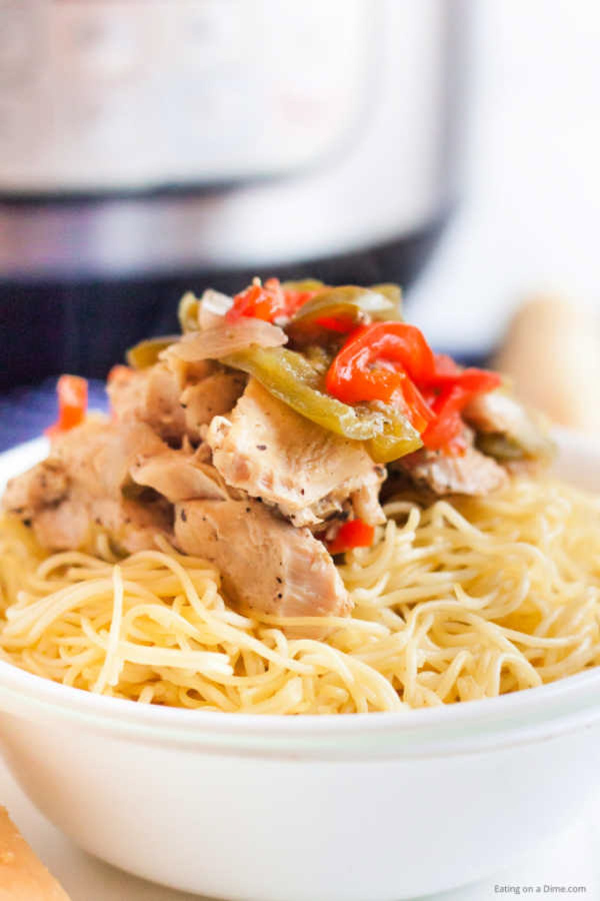 Instant Pot Chicken Scampi Recipe can be ready in minutes. Loaded with tender chicken and colorful bell peppers, this recipe is easy for busy weeknights. Close up image of a bowl of chicken scampi over pasta.