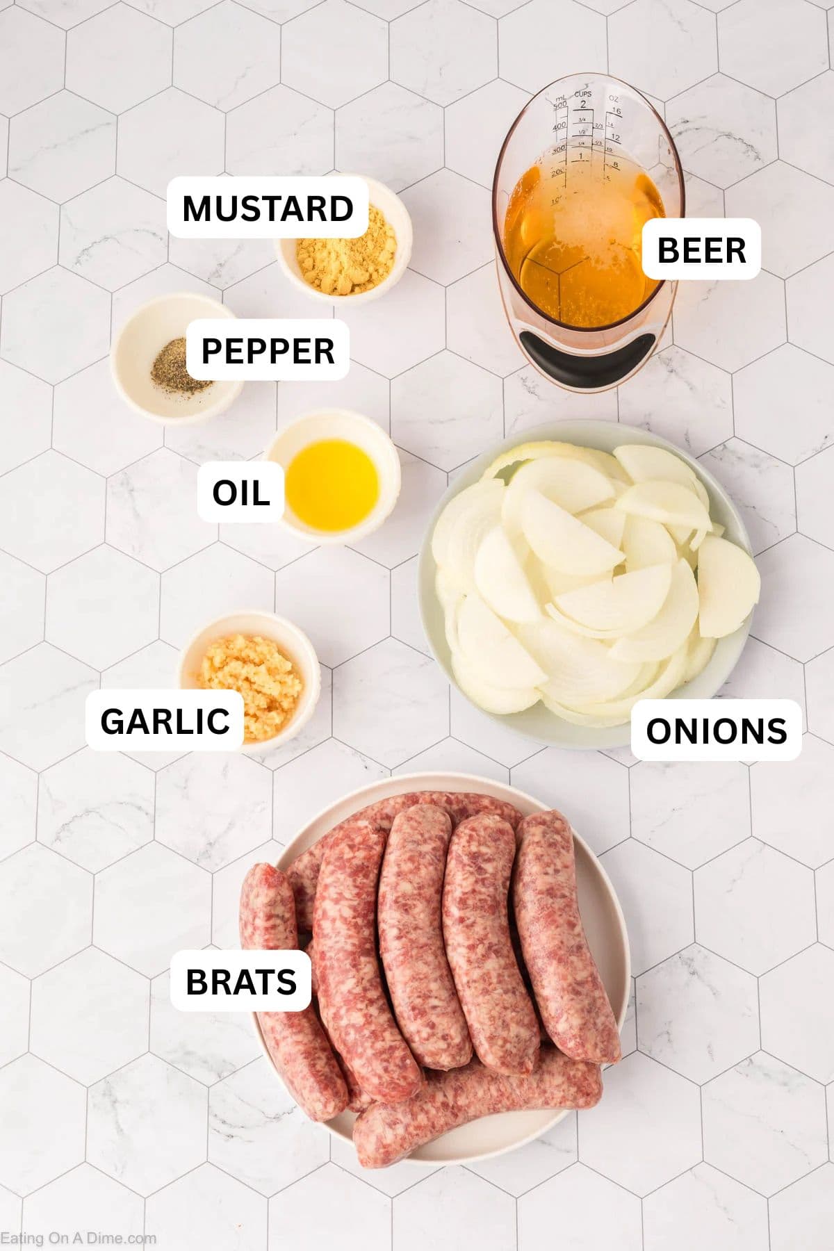 Slow Cooker Brats ingredients - onion, minced garlic, oil, brats, beer, mustard, pepper.