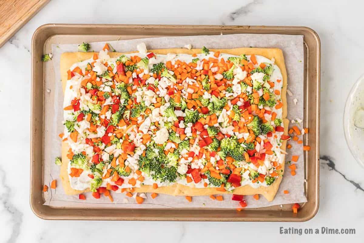 Topping the crust with the chopped fresh veggies