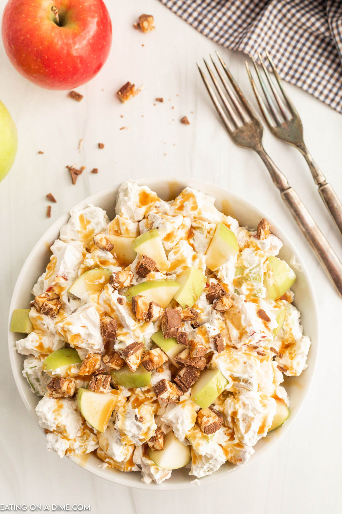 Apple Snickers Salad combined together and topped with extra apples and snickers in a bowl