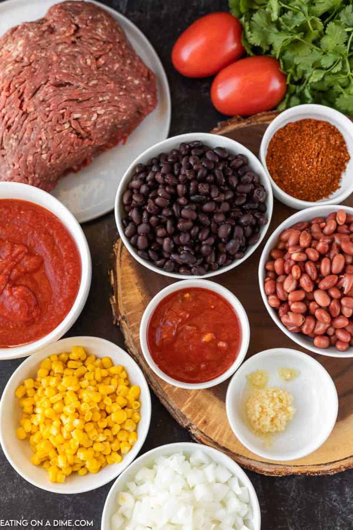 Ingredients to make taco chili: ground beef, pinto beans, black beans, onion, corn, crushed tomatoes, salsa, taco seasoning and garlic salt 