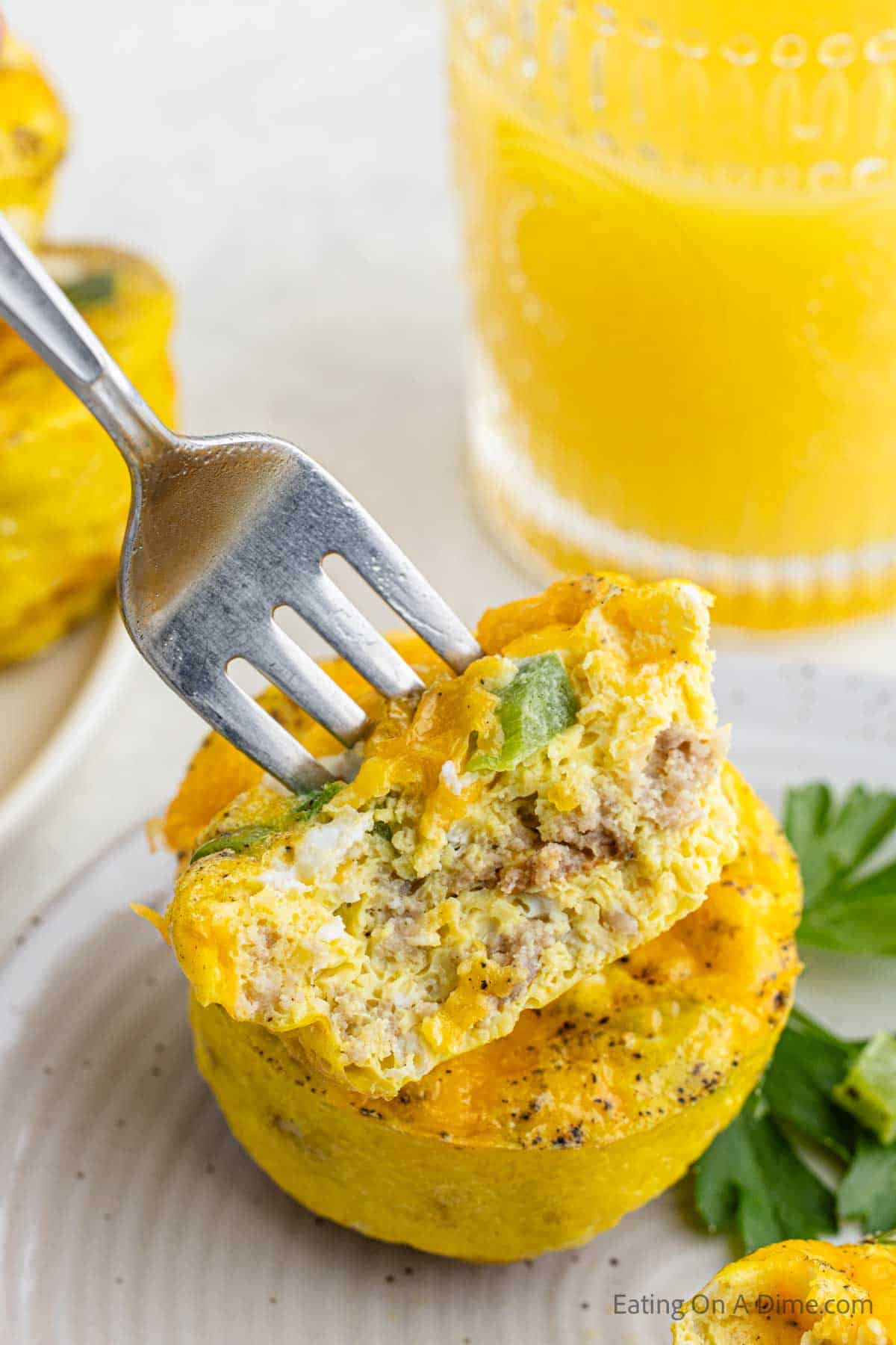 Egg muffins on a fork stacked on a plate