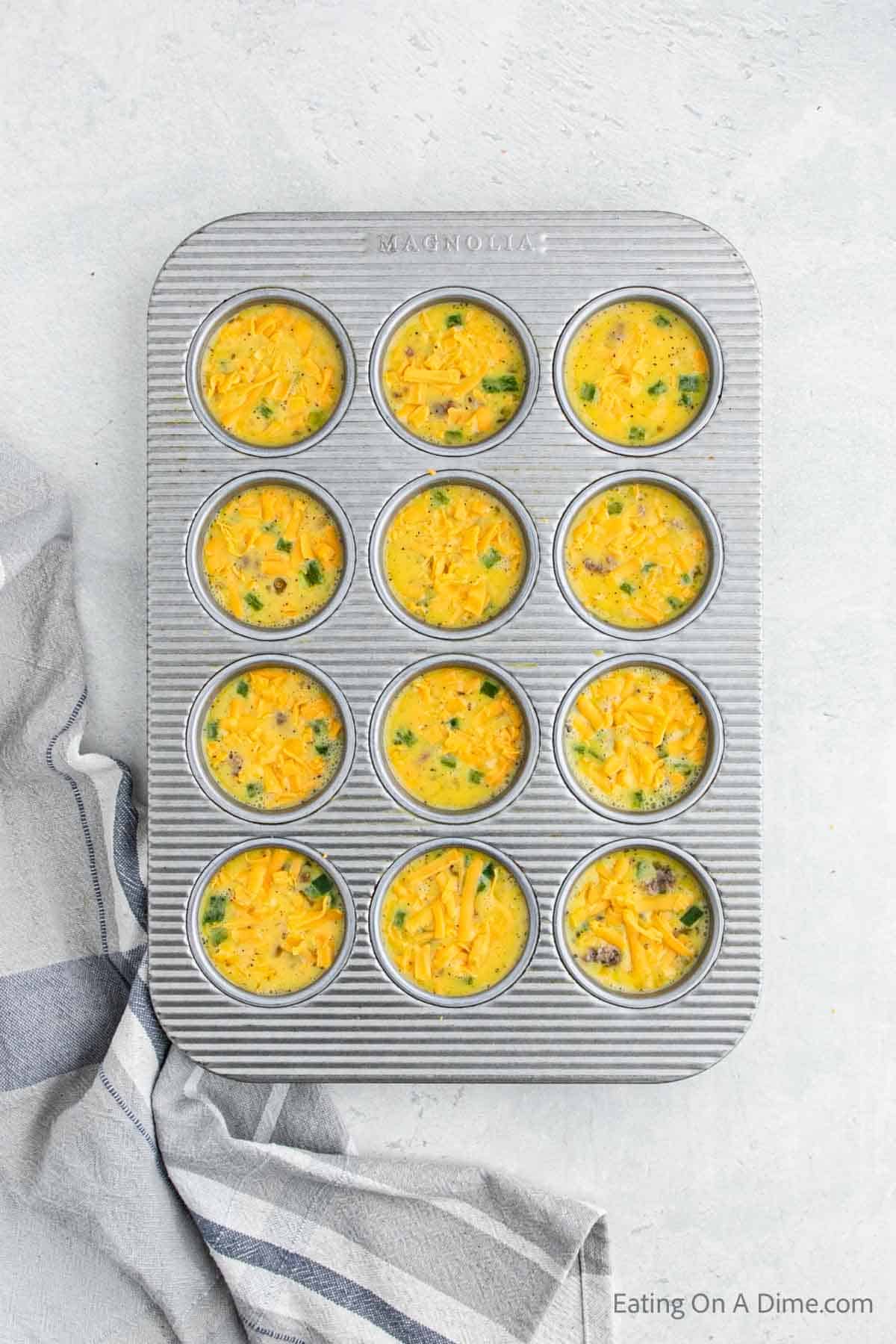 Topping the eggs with scrambled eggs in the muffin tin