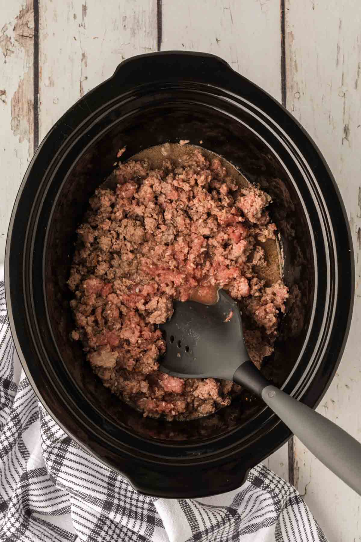 Chopping up ground beef in the slow cooker