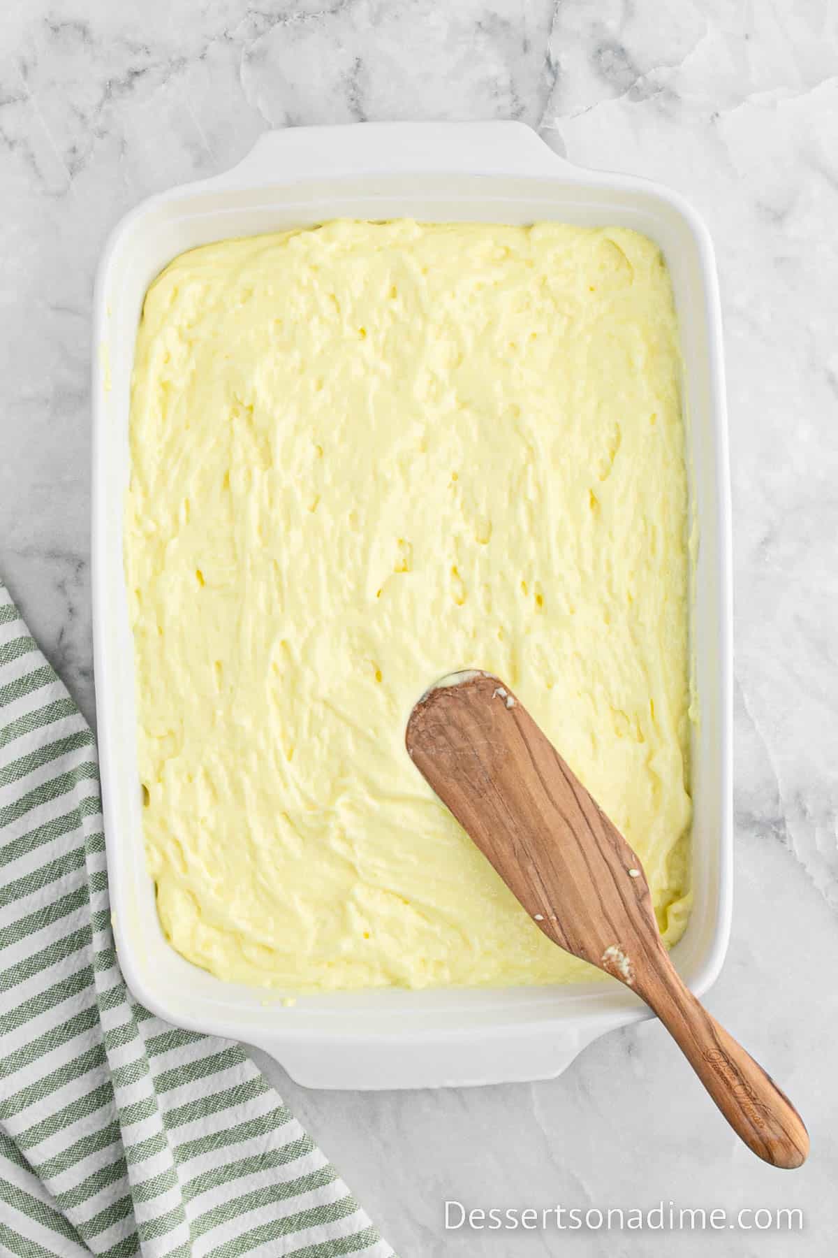 Spreading the lemon mixture in the baking dish with wooden spoon