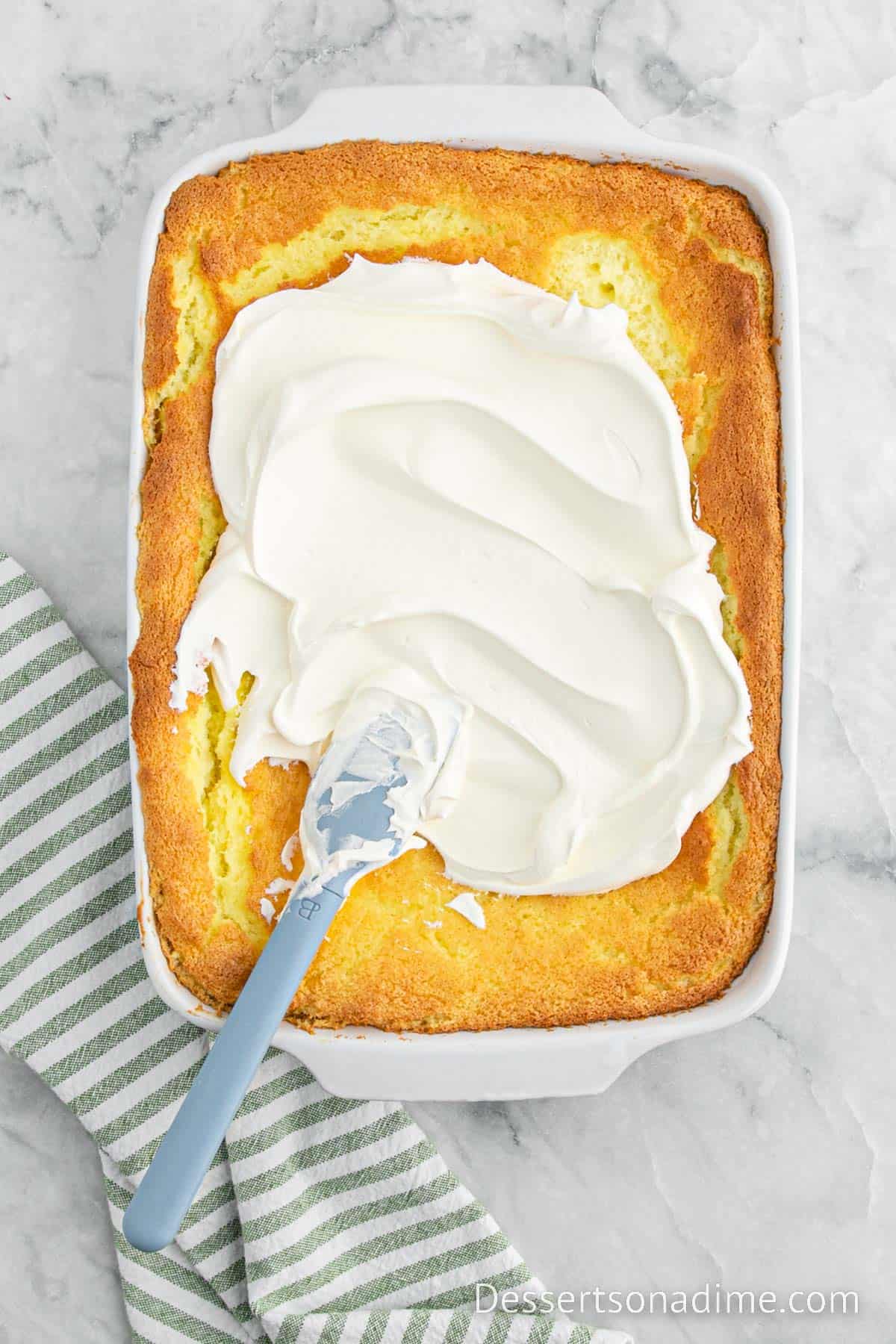 Topping the angel food cake with whipped topping