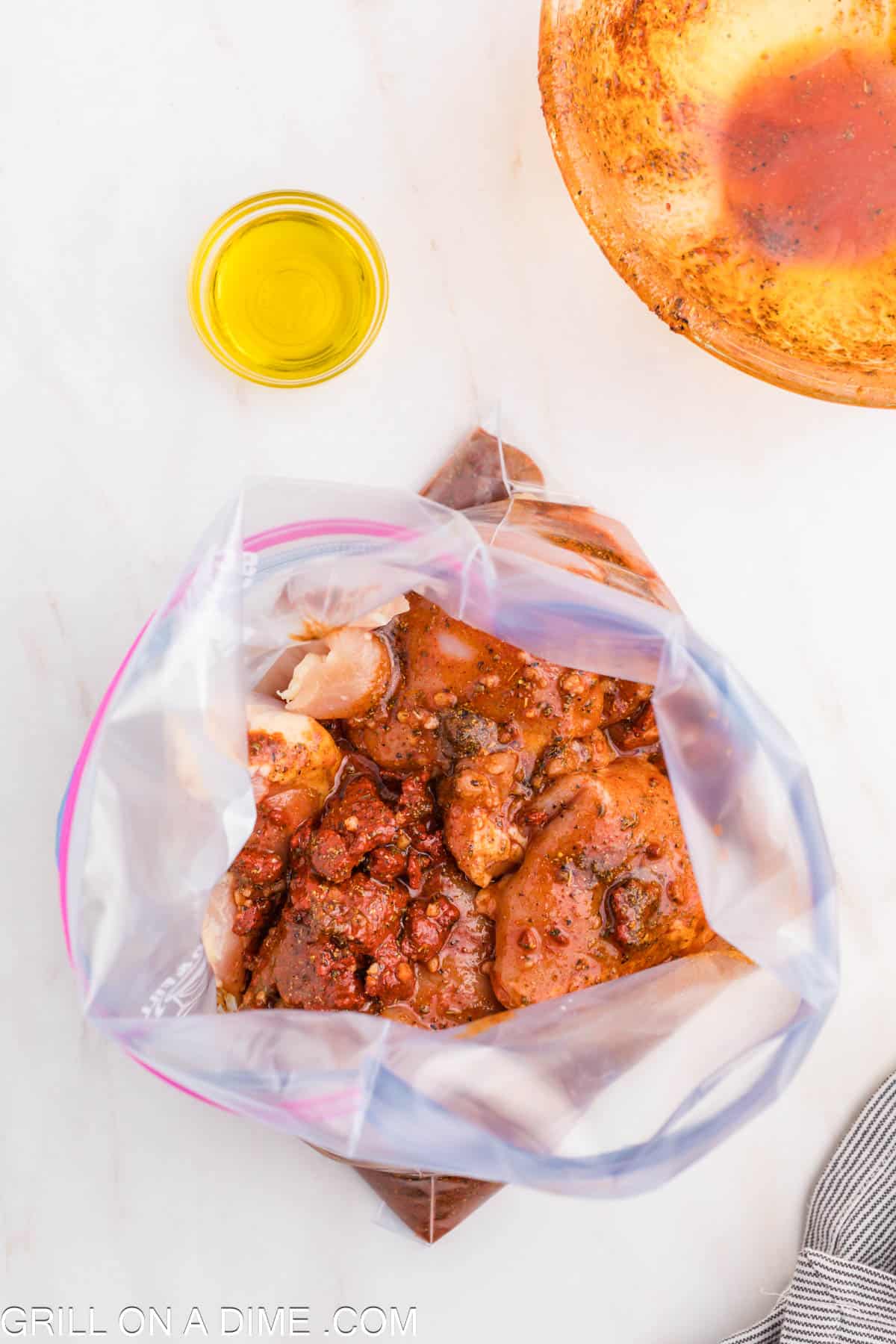 Placing the chicken and marinade in a zip lock bag