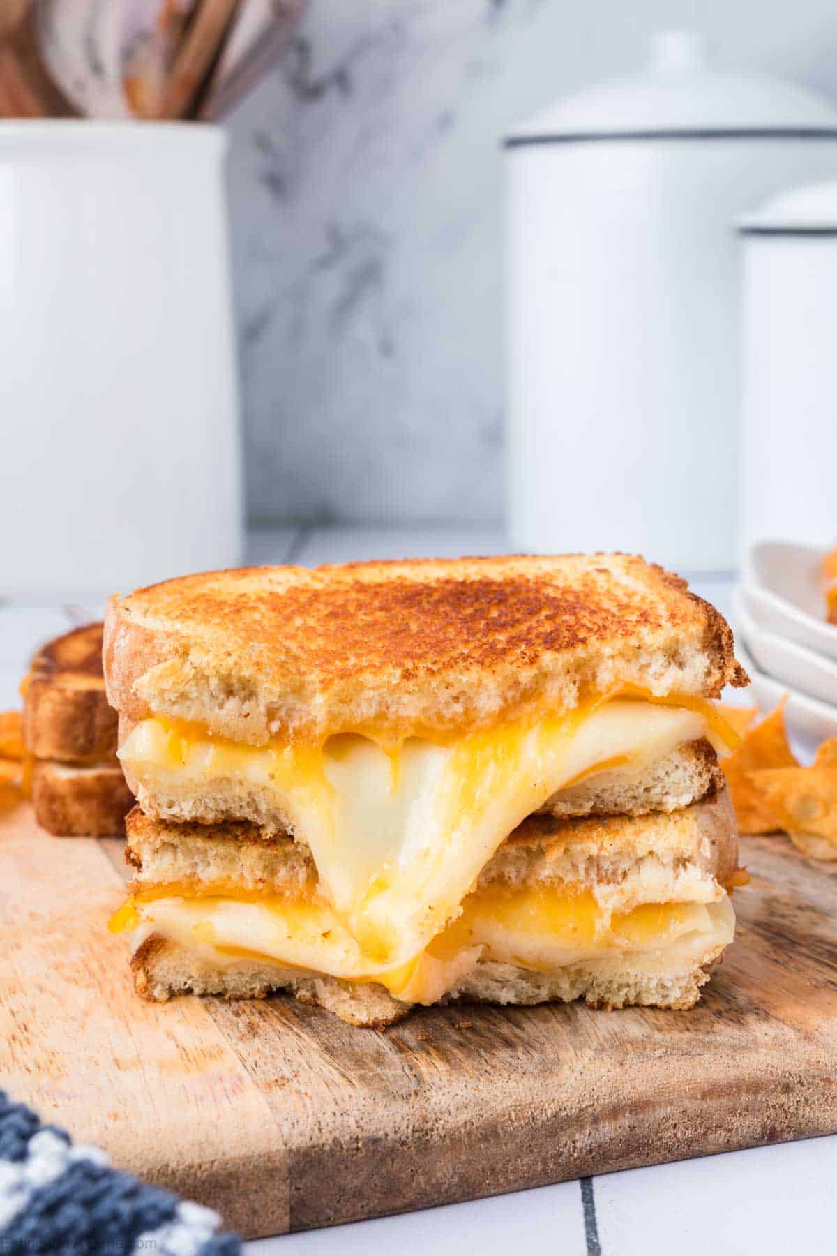 Grilled Cheese cut in half stacked on a cutting board