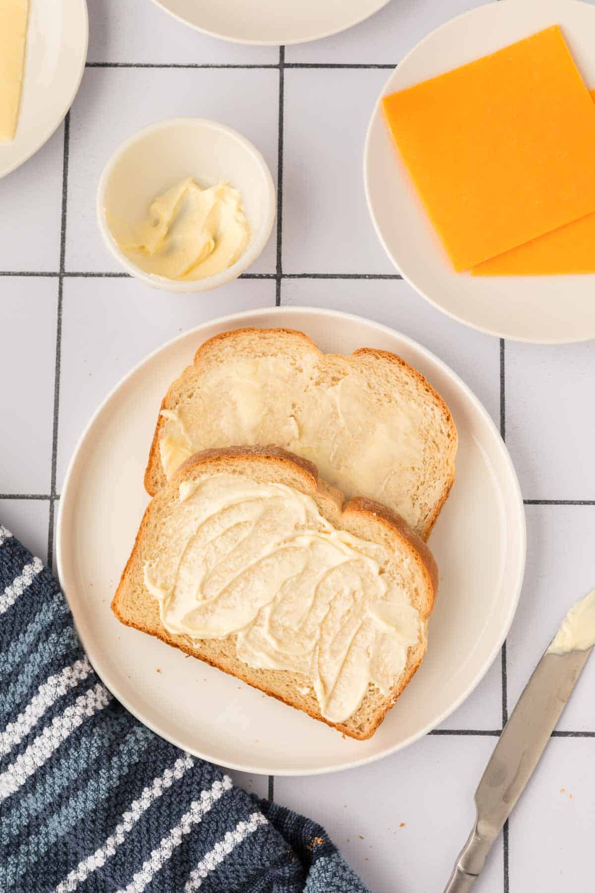 Spreading butter on slice of bread on a plate