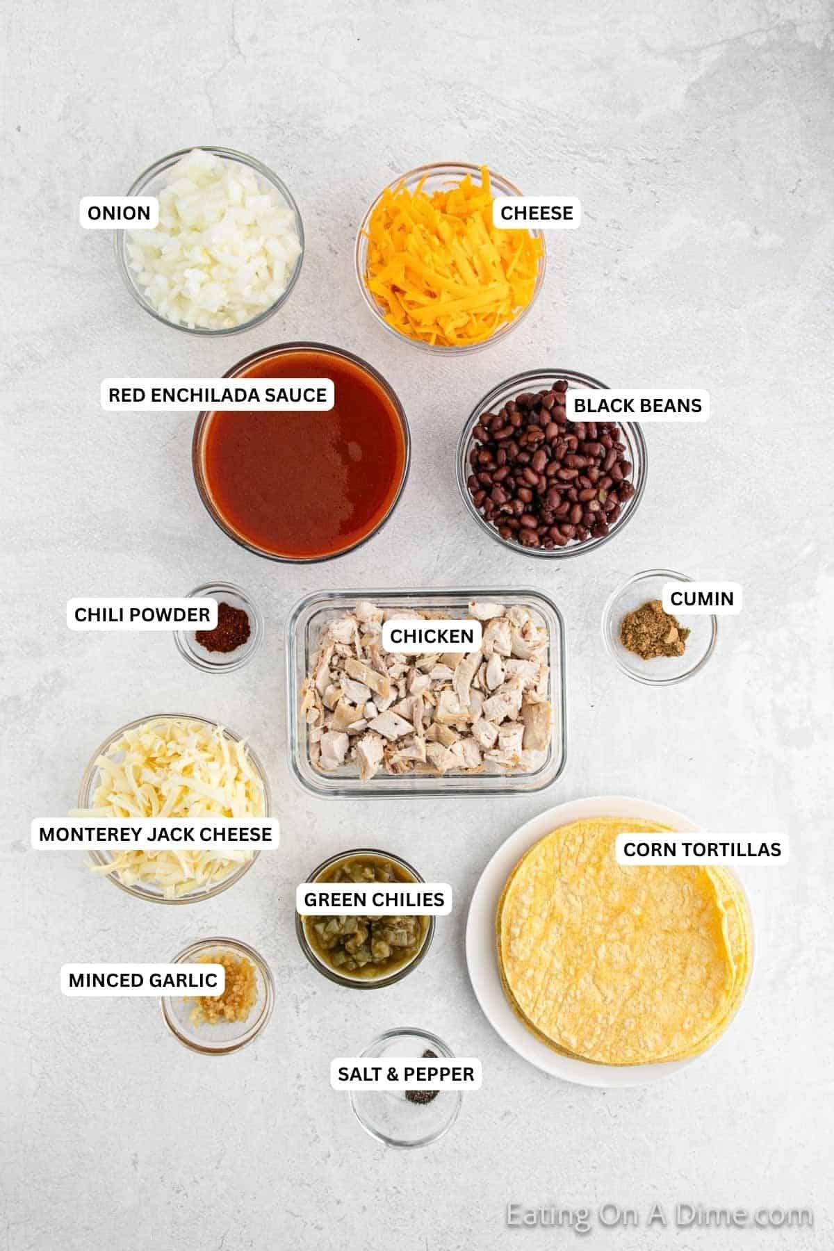Ingredients for recipe: corn tortillas, salt, pepper, minced garlic, green chilies, cheese, chicken, chili powder, cumin, black beans, enchilada sauce and onion.