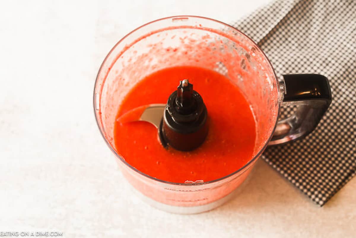 The strawberries being pureed in a food processor