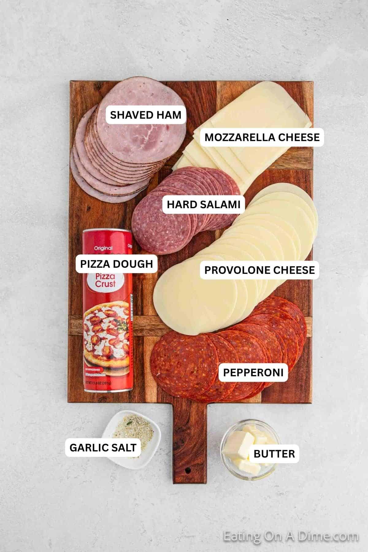 Ingredients for recipe: butter, garlic salt, pepperoni, pizza dough, provolone cheese, salami, ham and mozzarella cheese.