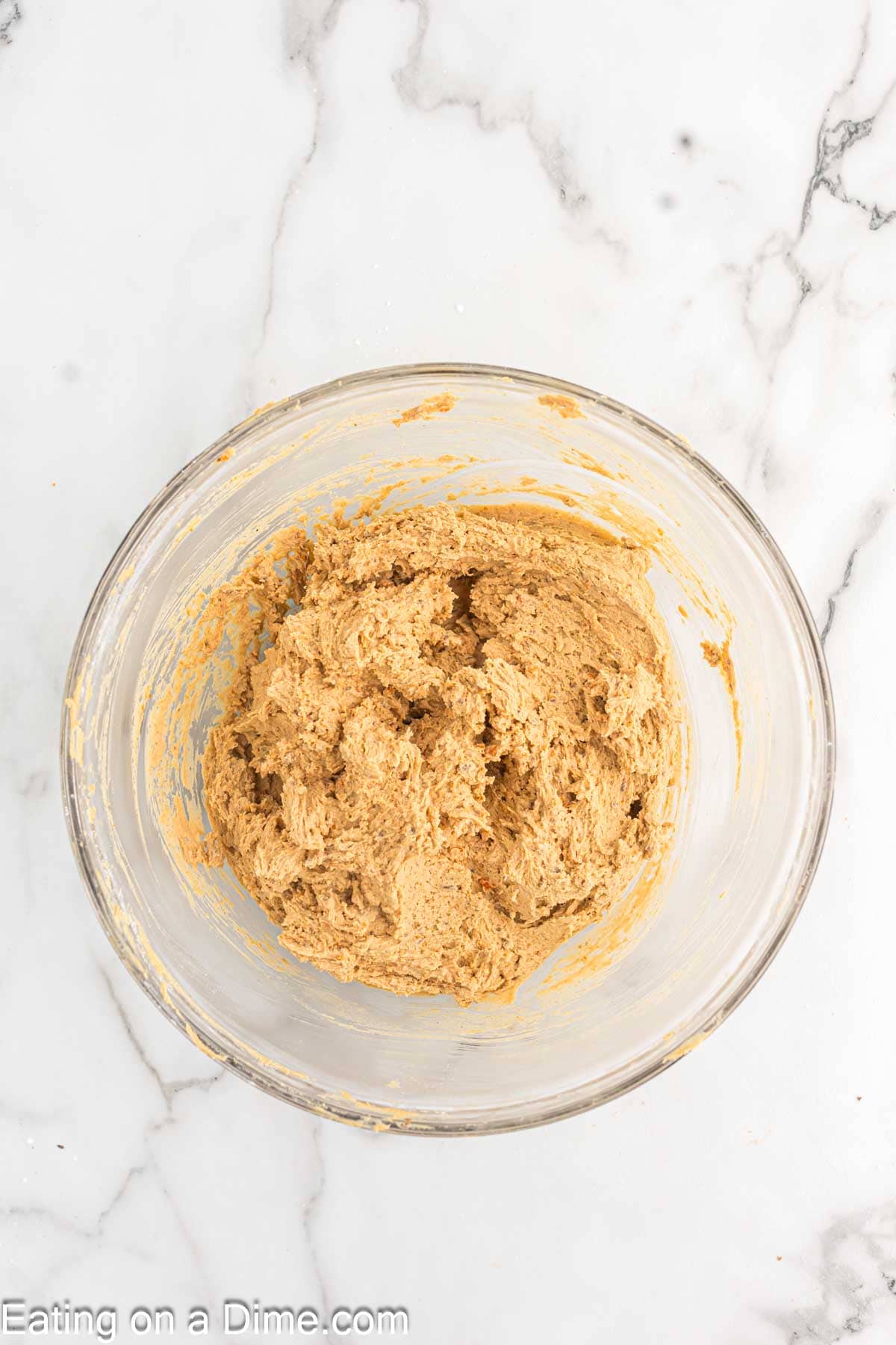 Butterfinger pieces mixed with the peanut butter mixture in a bowl