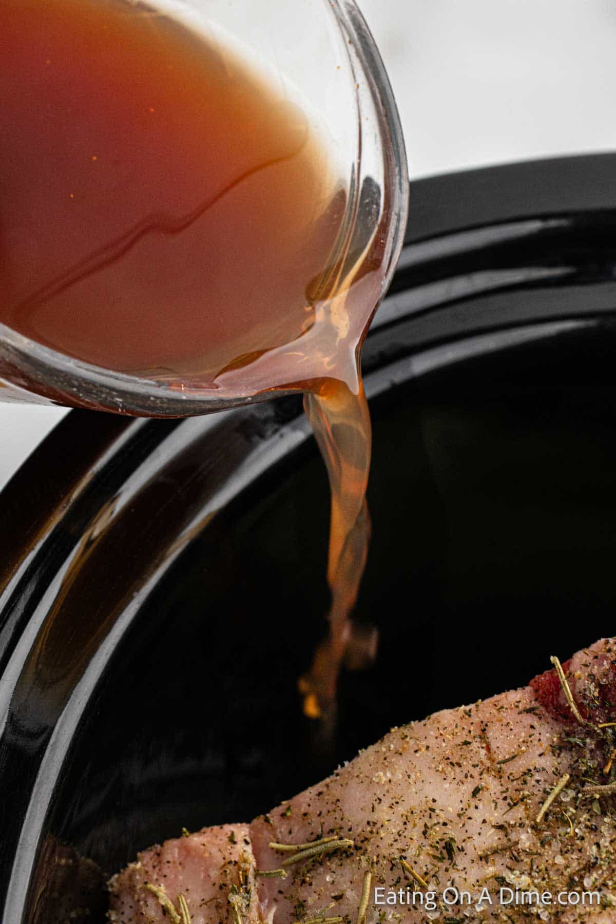 Pouring beef broth into the slow cooker