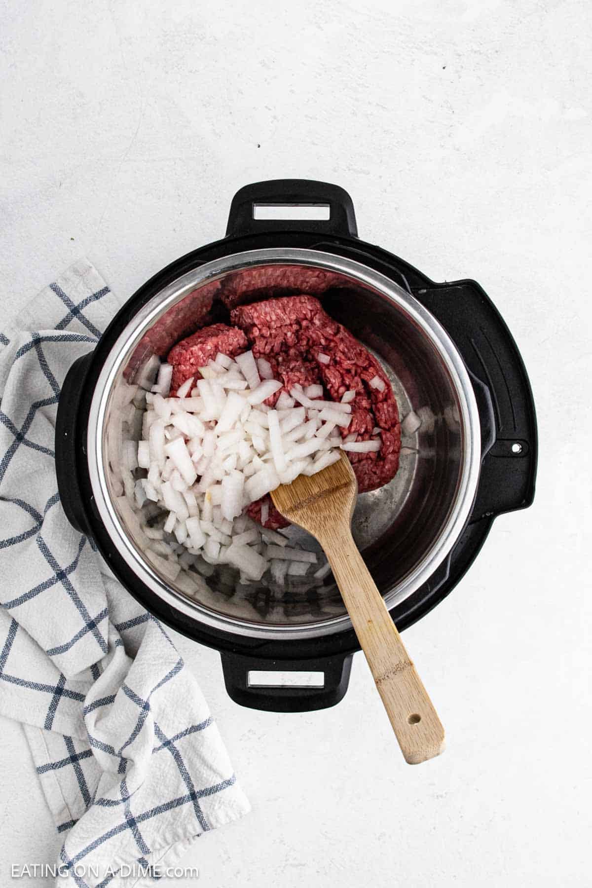 Ground beef and diced onions in the instant pot.