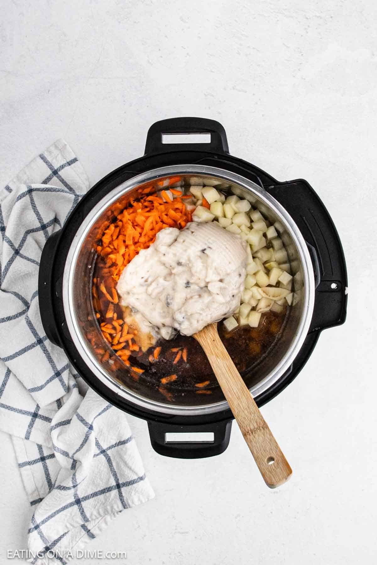 Cream of mushroom soup added to the shredded carrots and diced potatoes in the instant pot.