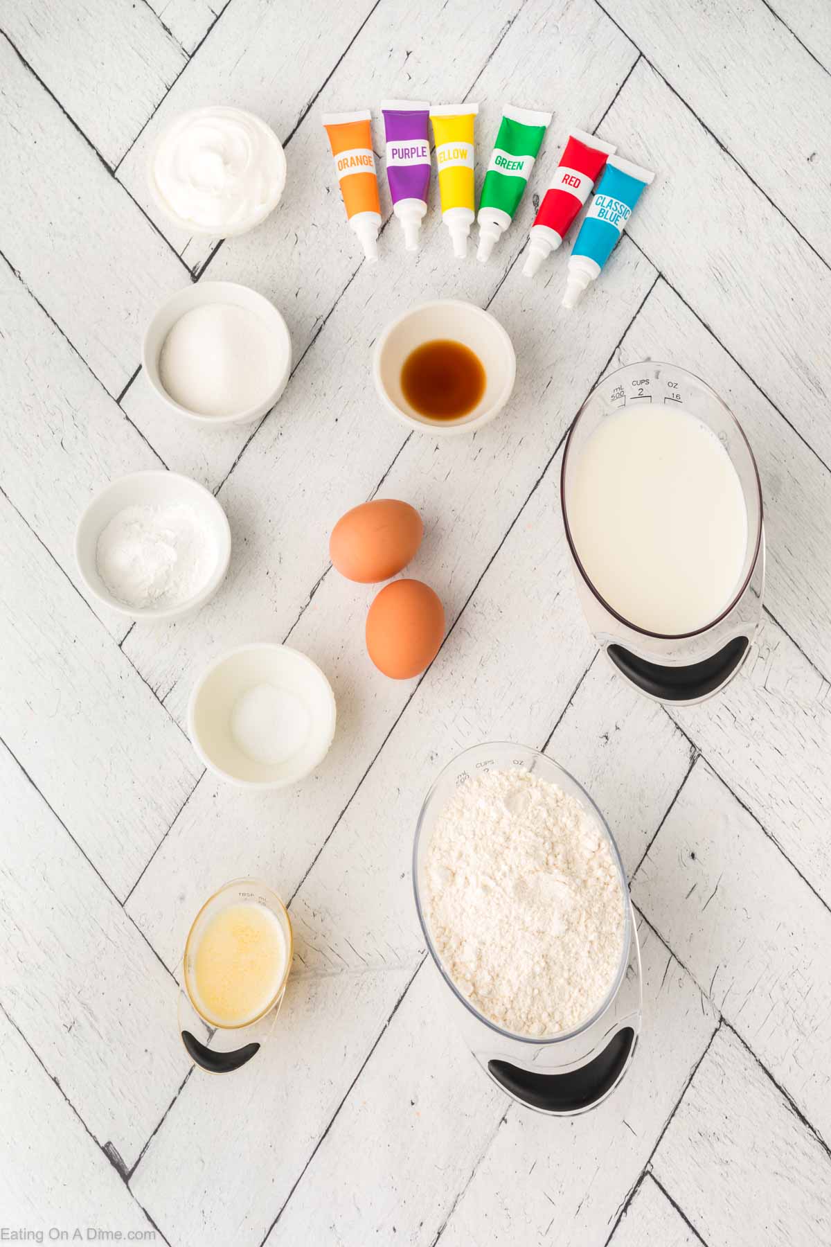 Rainbow pancakes ingredients - flour, sugar, baking powder, salt, eggs, milk, butter, vanilla extract, food coloring, whipped cream