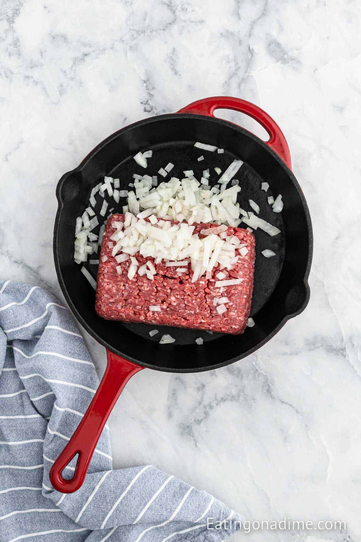 Cooking ground beef with chopped onions in a cast iron skillet
